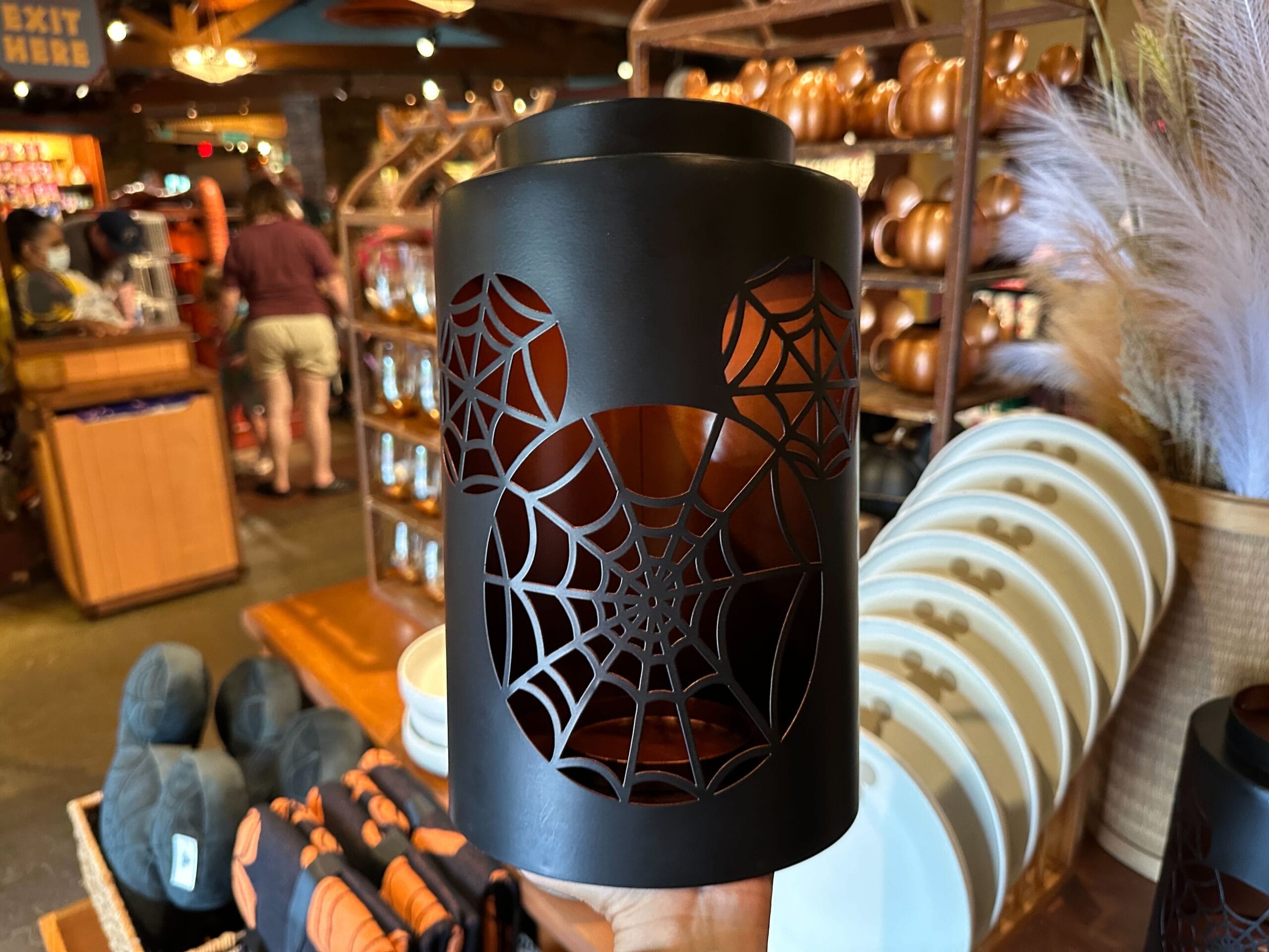 Black lantern with a Mickey Mouse head and spiderweb—perfect Halloween Home Decor, seen at Animal Kingdom store shelves.