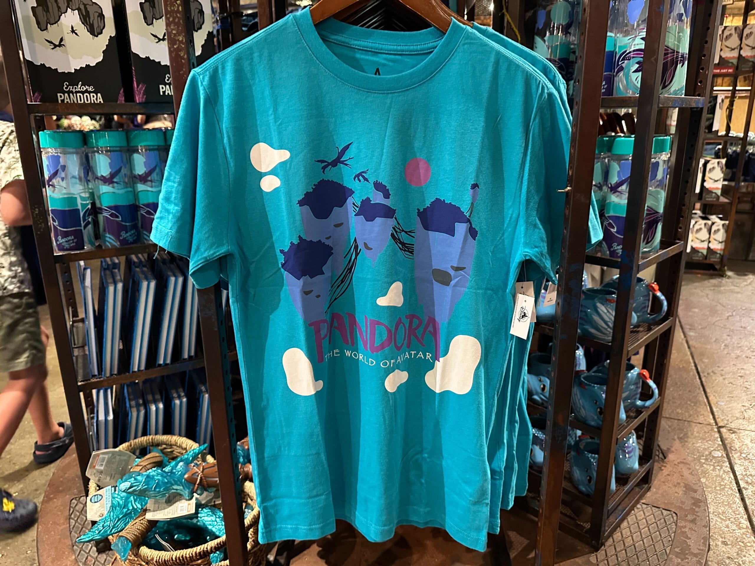 Teal T-shirt with floating mountains, birds, clouds—Pandora Merch text reads "Pandora The World of Avatar.