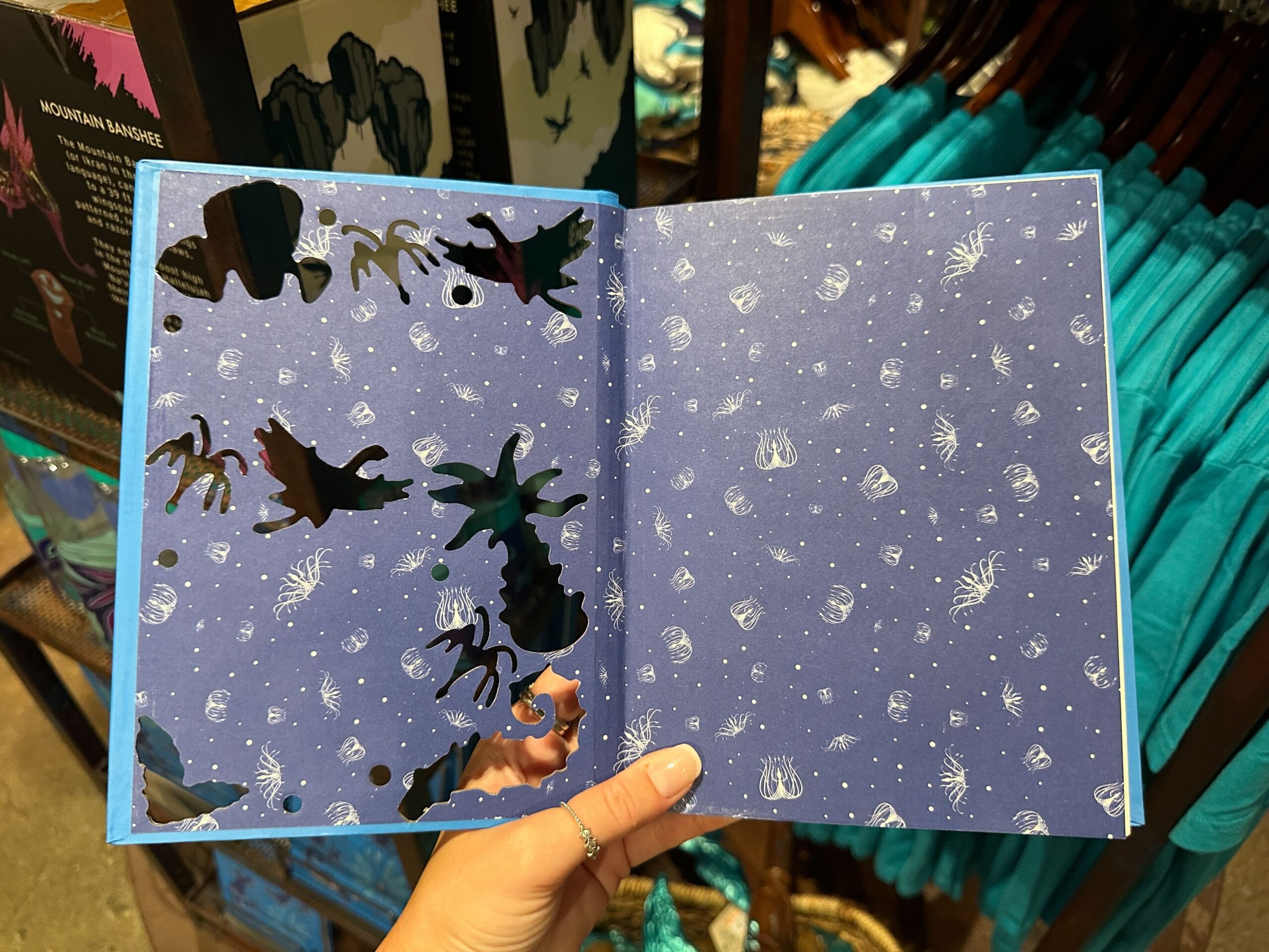 An open notebook with abstract black ink and white sea creature doodles, inspired by Pandora merchandise.