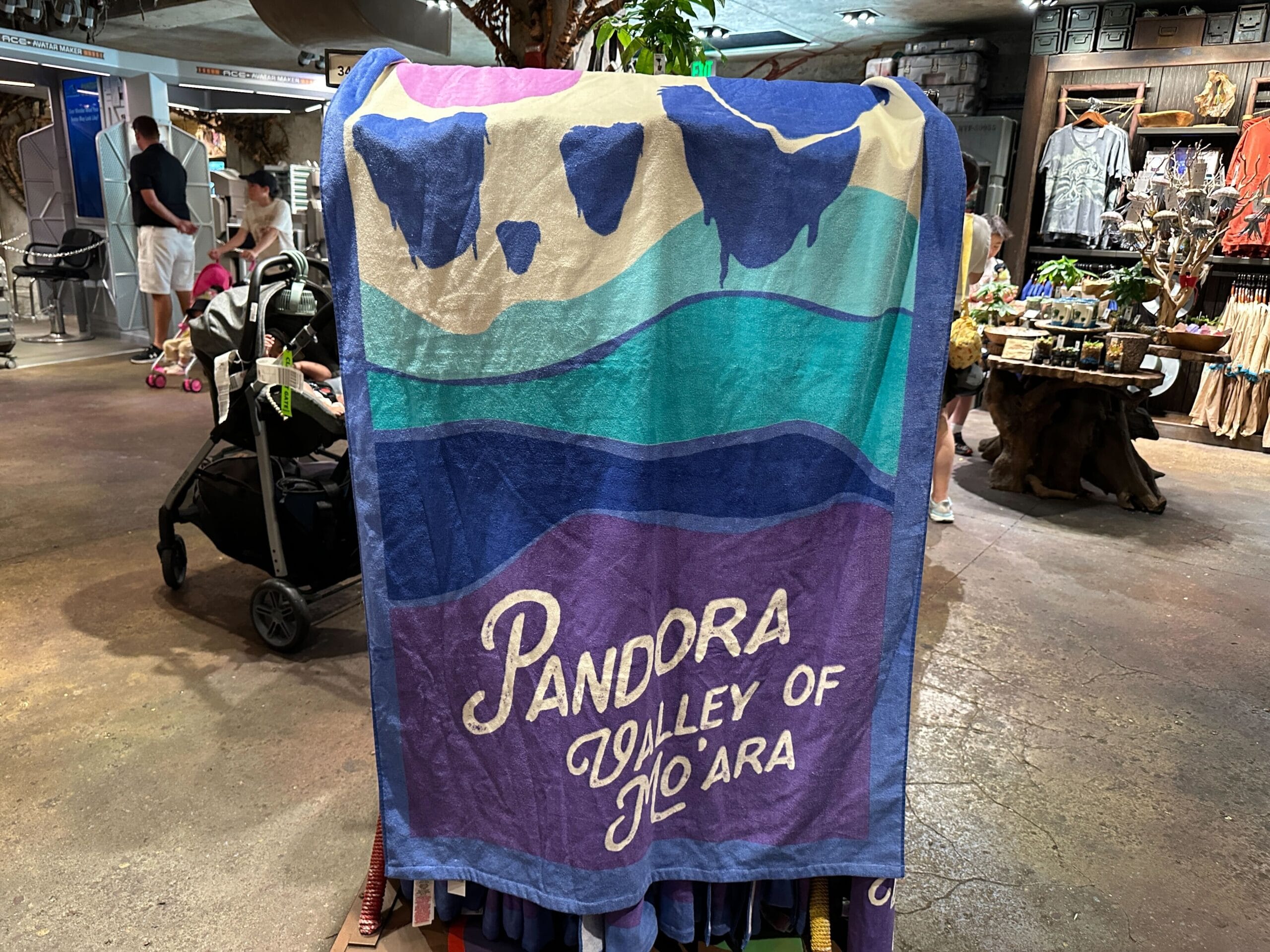 A colorful towel with "Pandora Valley of Mo'ara" text, perfect for fans of Pandora merchandise, displayed in a gift shop.