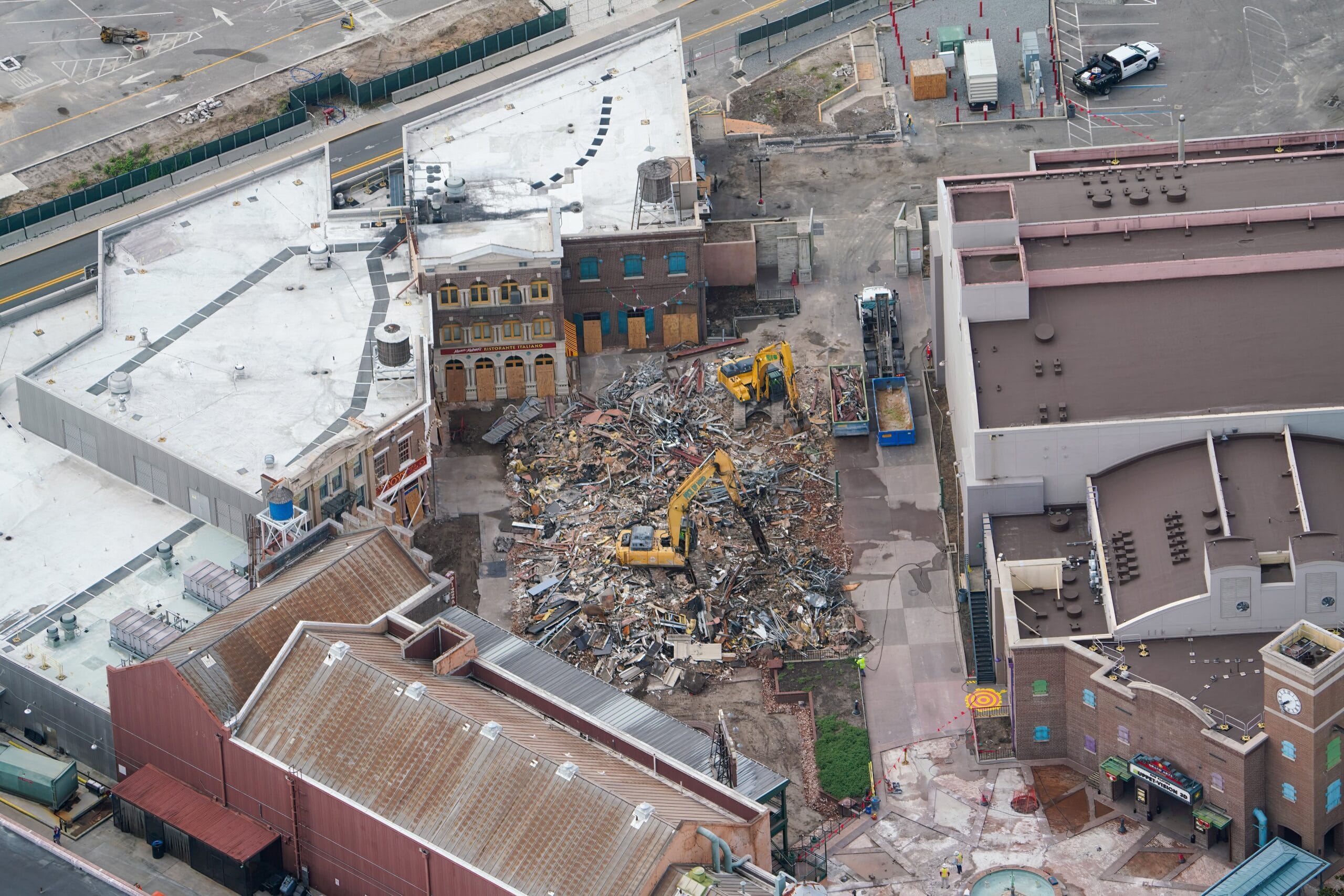 Aerial view of two excavators clearing debris near Disney's Hollywood Studios in an urban area.