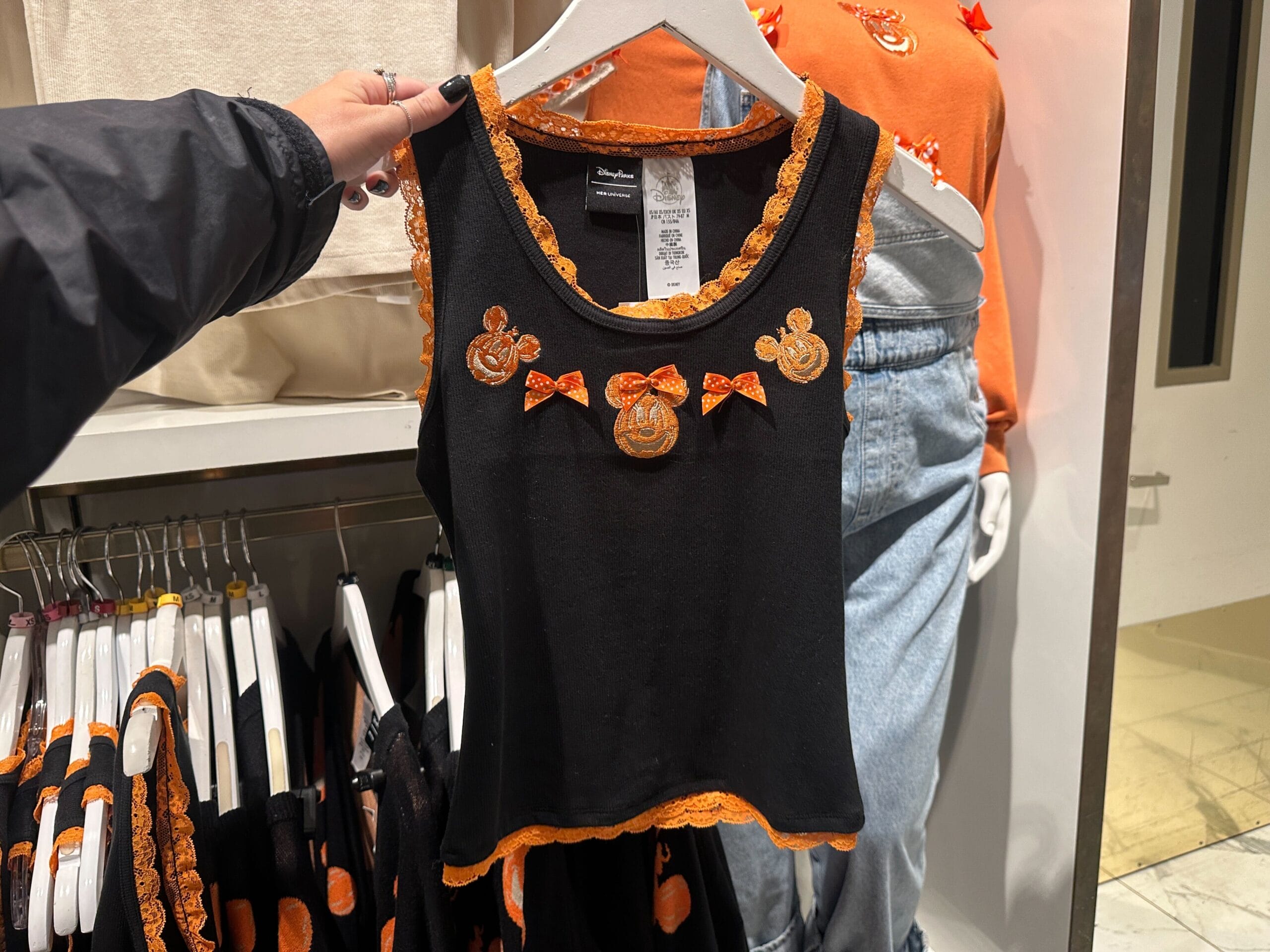 A black tank top with orange lace trim and Disney World Mickey Mouse pumpkin designs, perfect for Halloween.