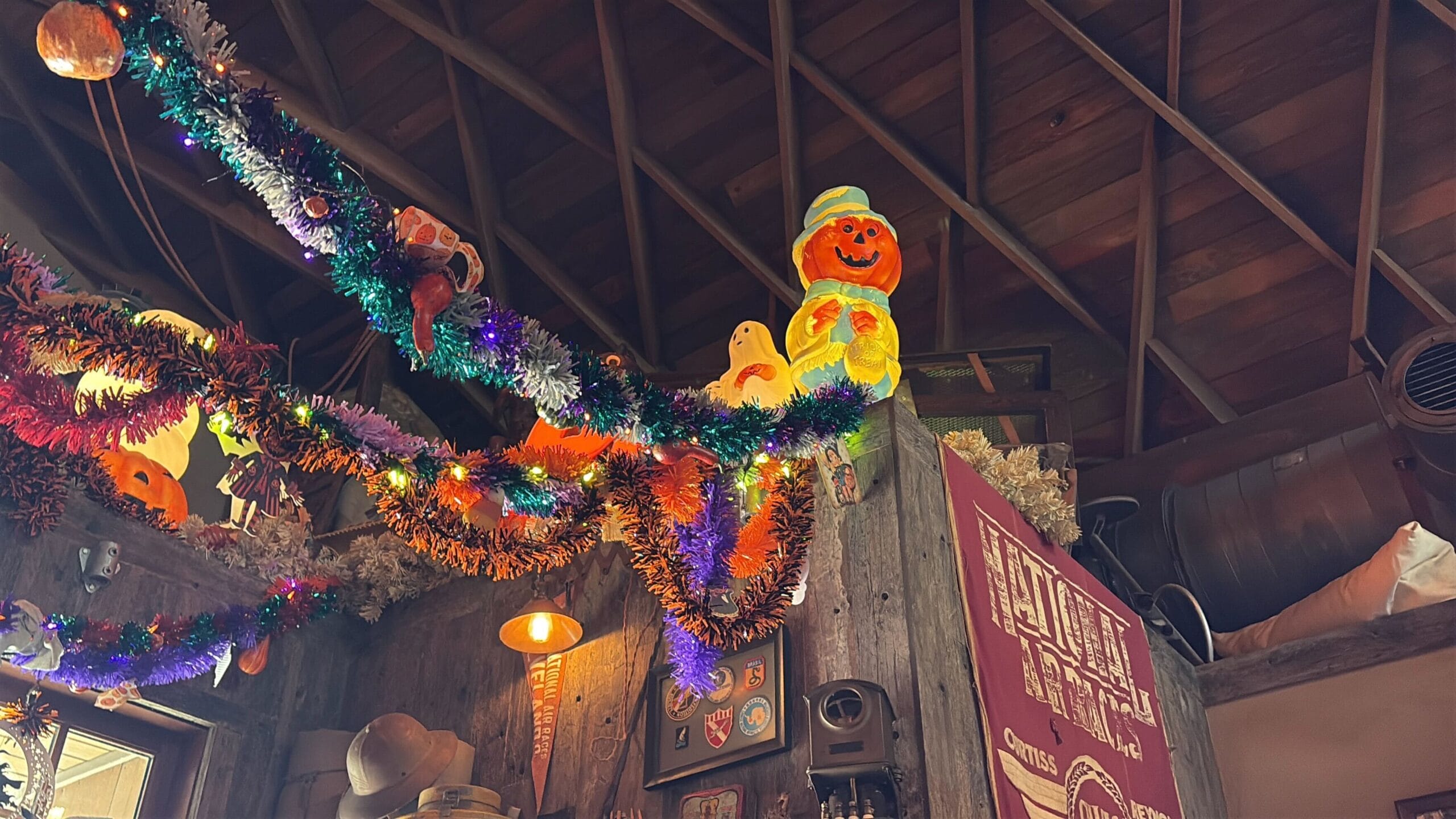 Colorful Halloween overlay with a pumpkin and ghost brightens this rustic room at Jock Lindsey's Hangar Bar, Disney Springs.