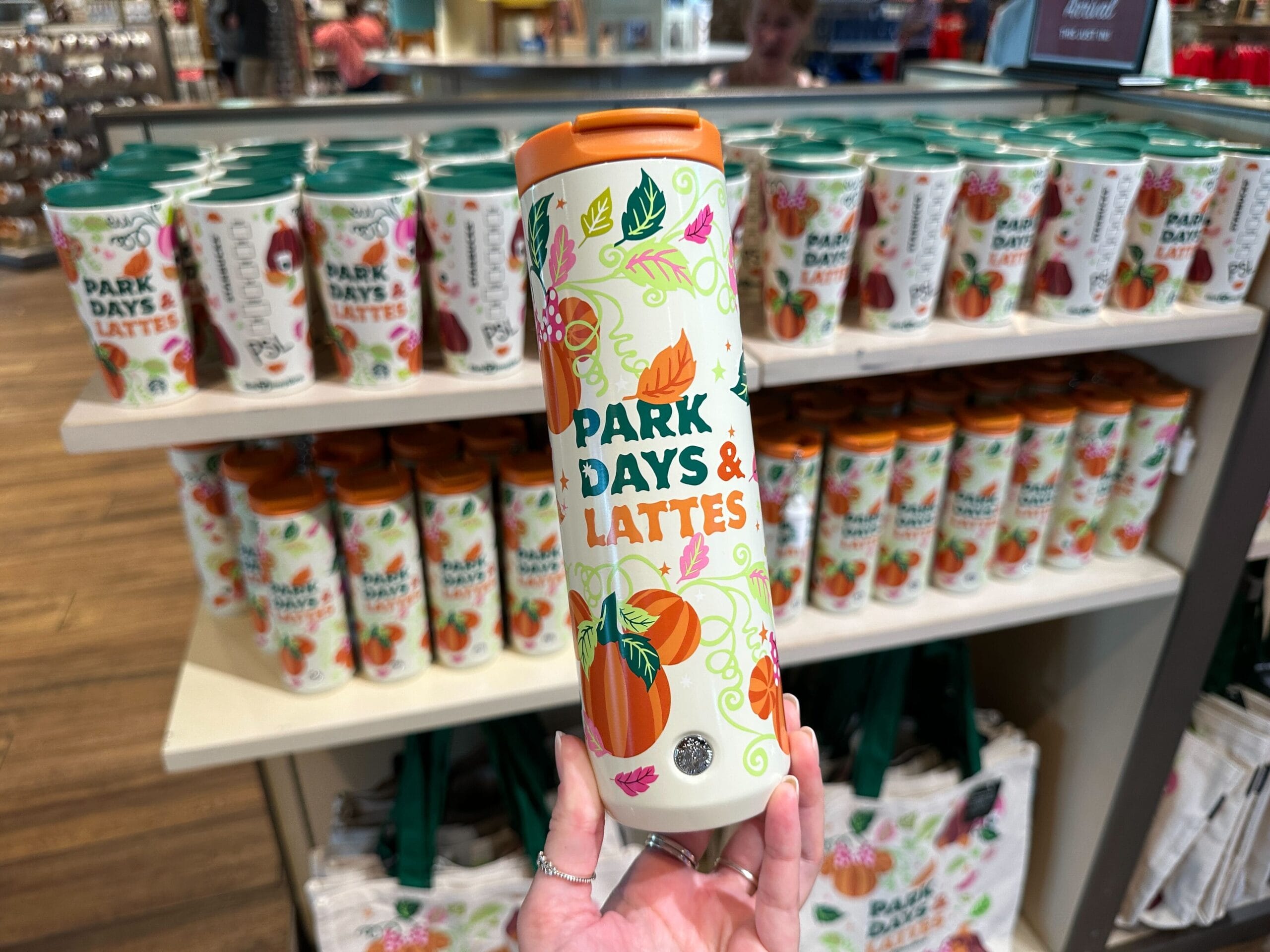Hand holding a Park Days and Lattes collectiontumbler with pumpkins, perfect for Disney Parks or Starbucks Pumpkin Spice fans.