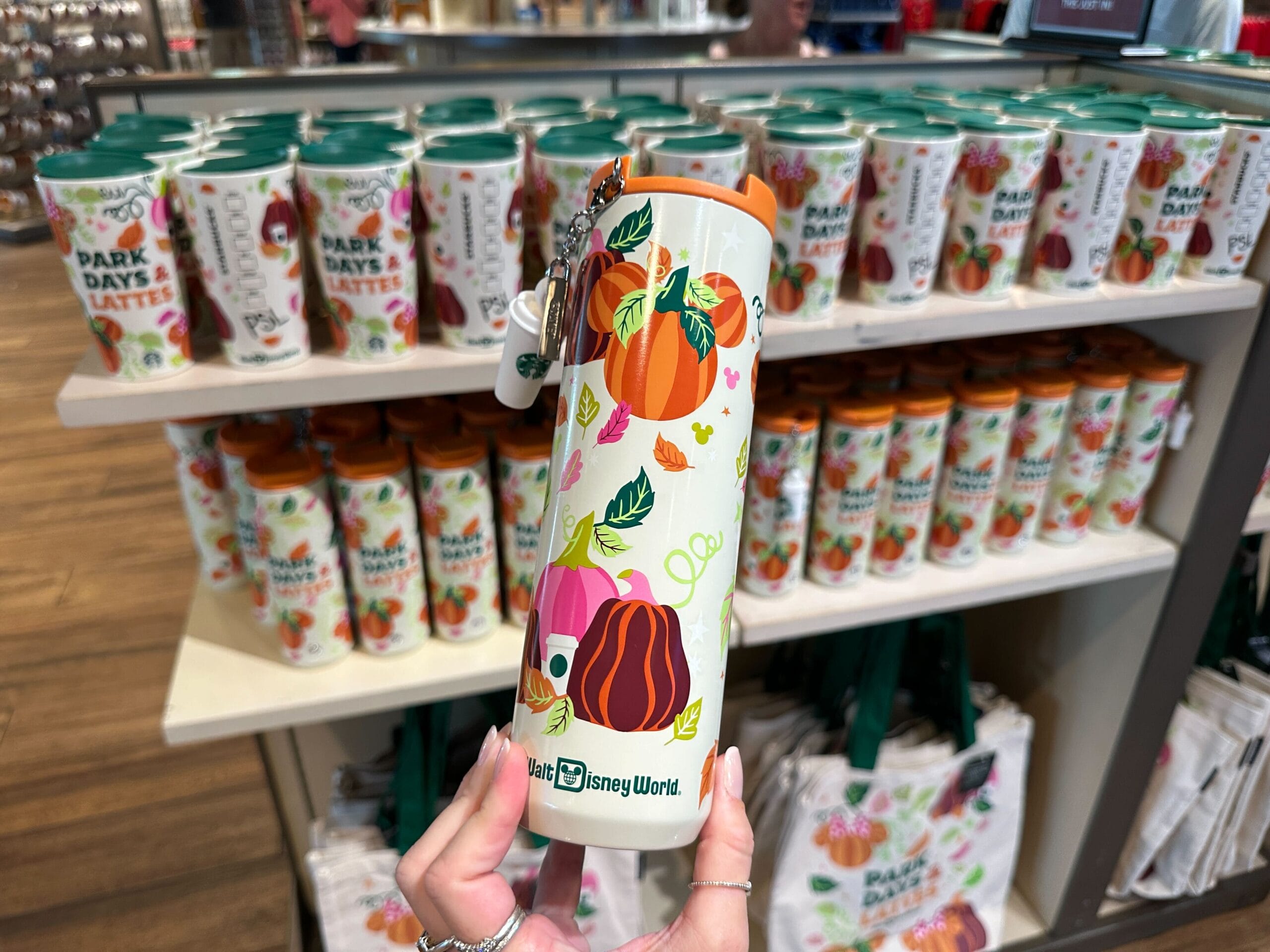 Hand holding a Walt Disney World tumbler with pumpkin designs part of Park Days and Lattes collection