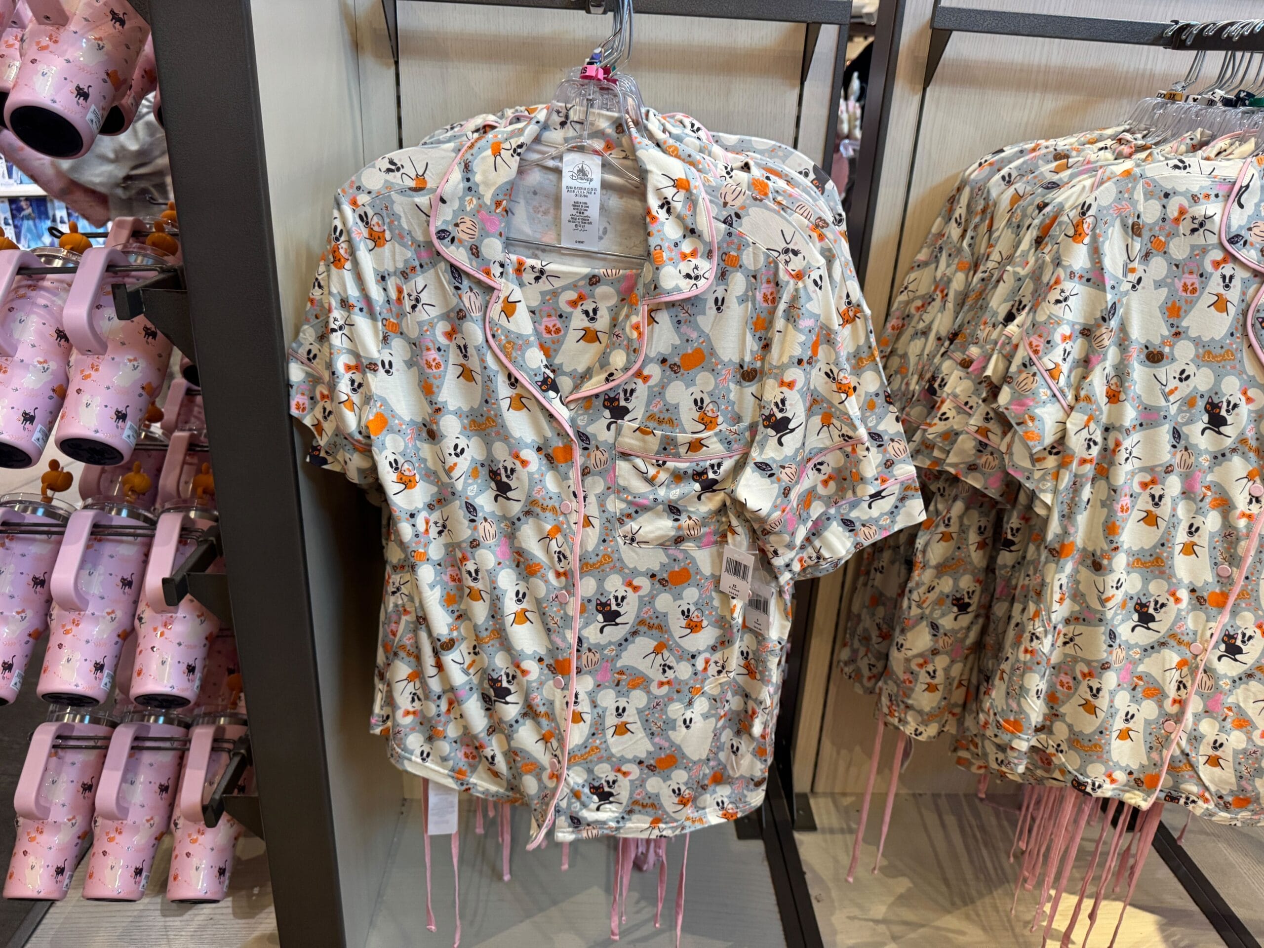 Short-sleeve pajama tops with a Pastel Halloween Minnie Mouse, pumpkins, and autumn leaves print on display.