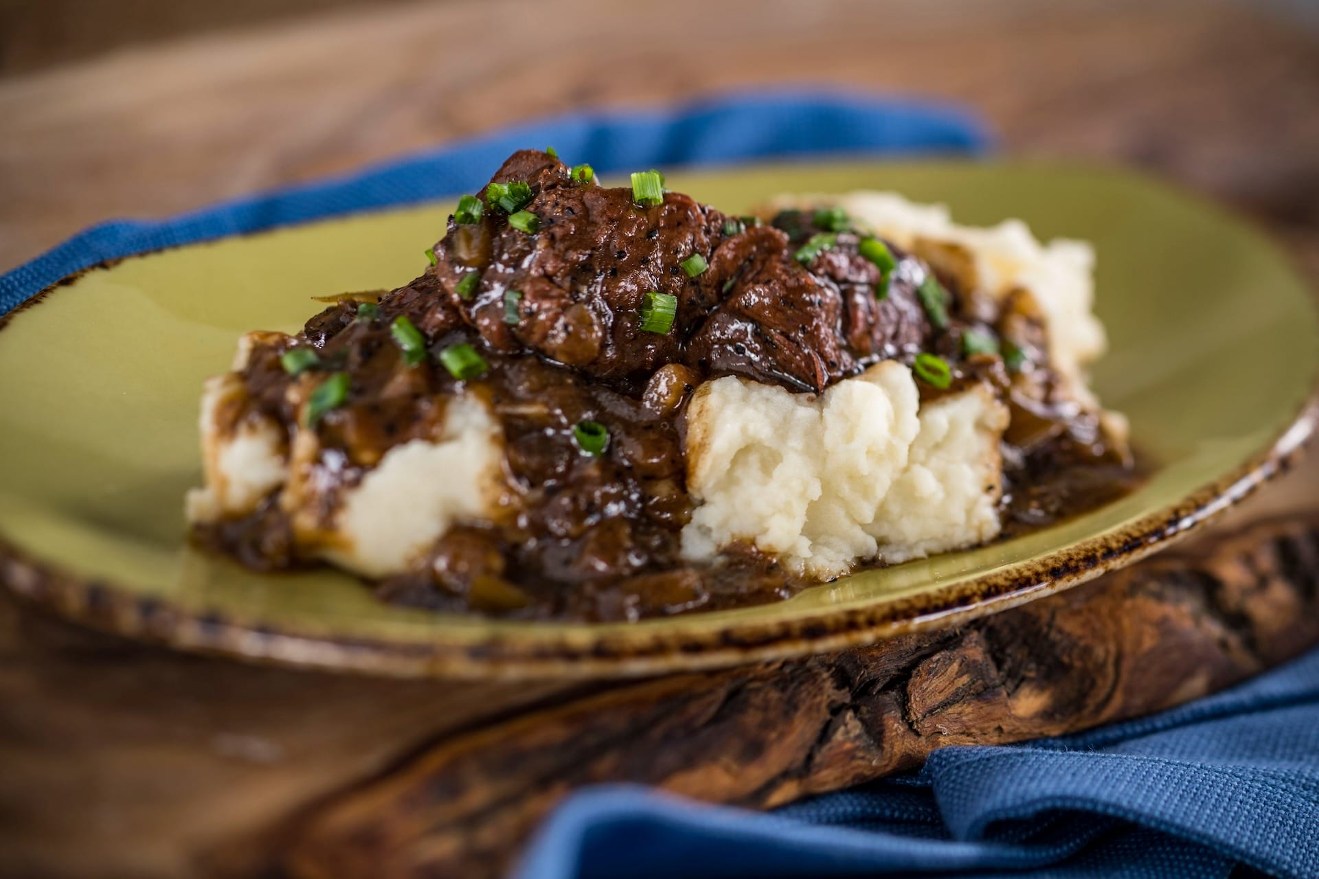 Mashed potatoes with beef and brown gravy, garnished with chives—just like at the EPCOT Food & Wine Festival full menus.