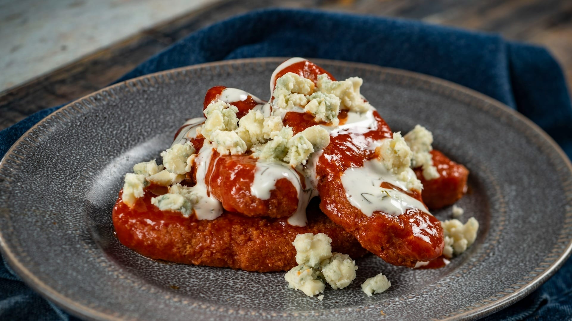 Buffalo chicken tenders with blue cheese and ranch, inspired by the EPCOT Food & Wine Festival, on a gray plate.