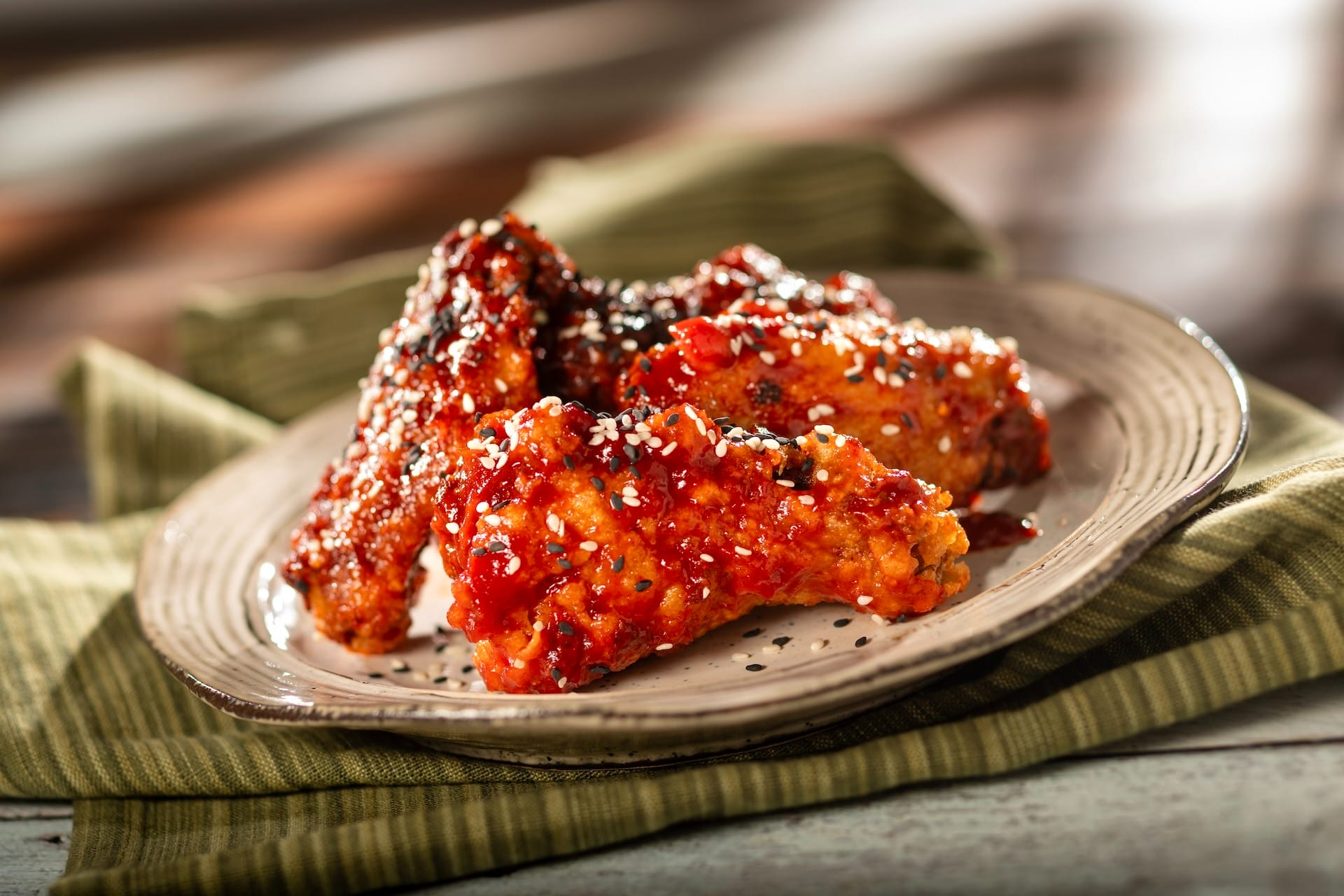 Crispy chicken wings coated in red sauce and sesame seeds, inspired by EPCOT Food & Wine Festival menus.