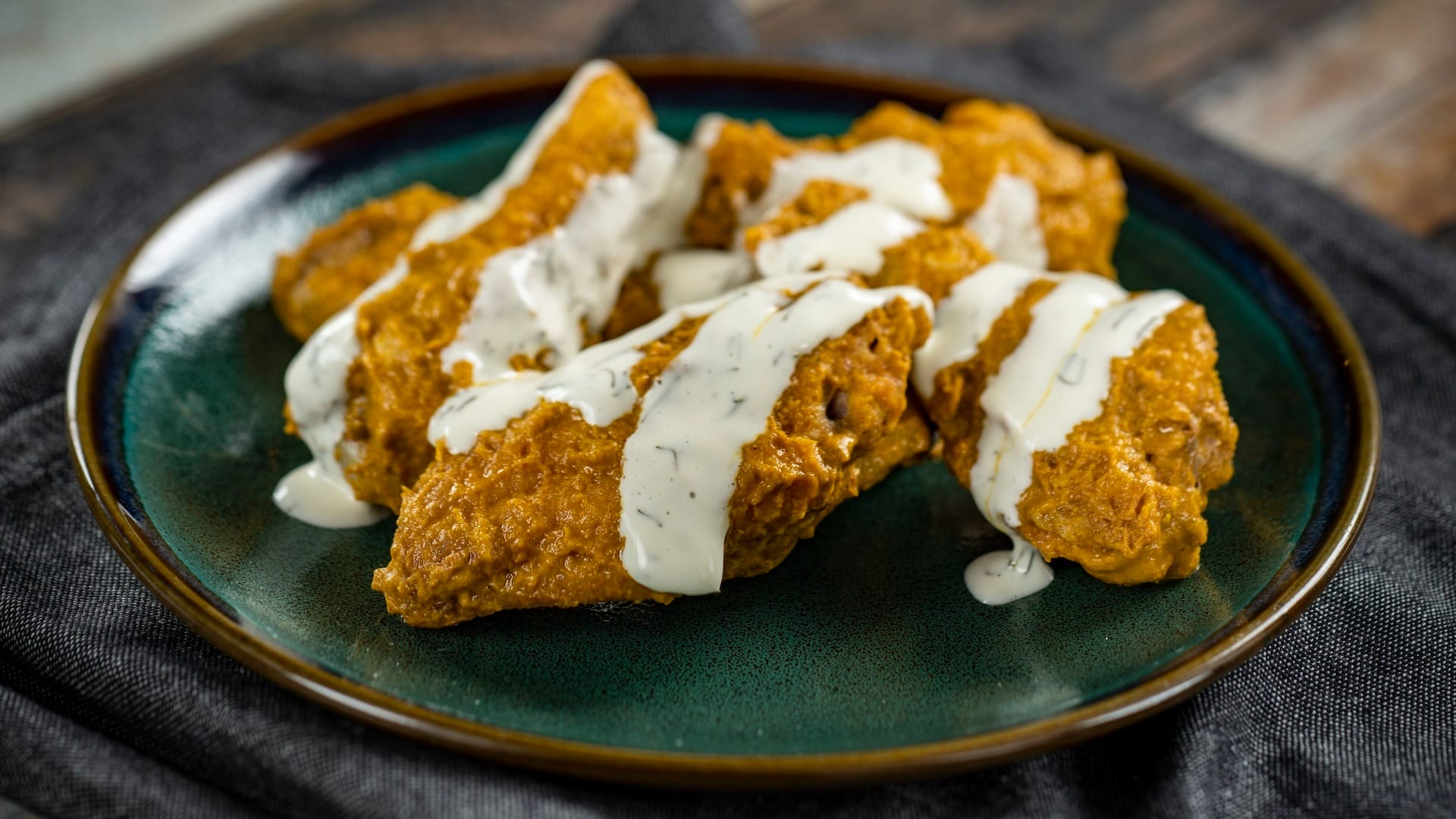 Buffalo-style chicken wings topped with ranch dressing, featured at the 2025 EPCOT Food & Wine Festival.