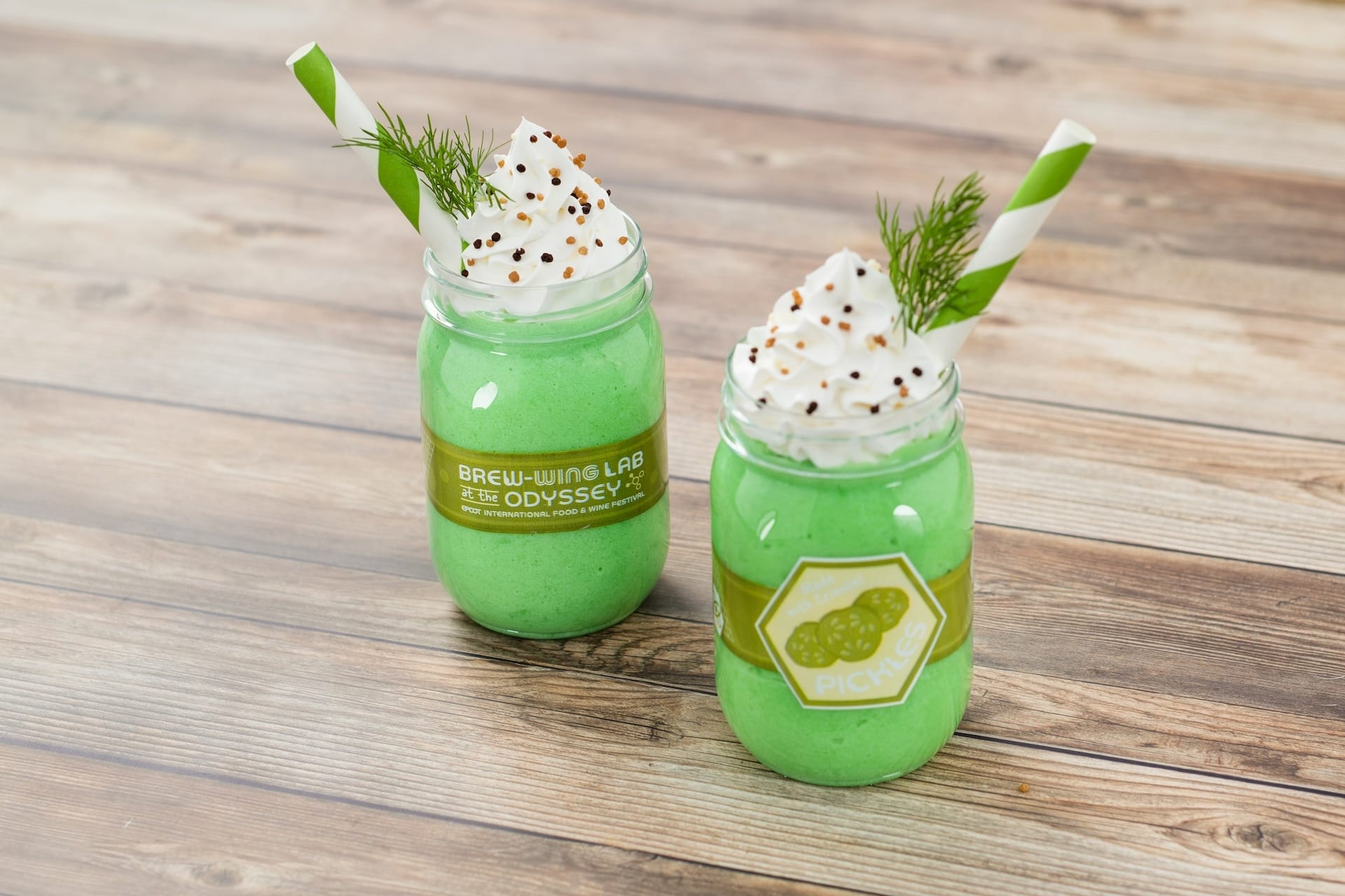 Two green milkshakes in jars topped with whipped cream, sprinkles, and dill at the 2025 EPCOT Food & Wine Festival.