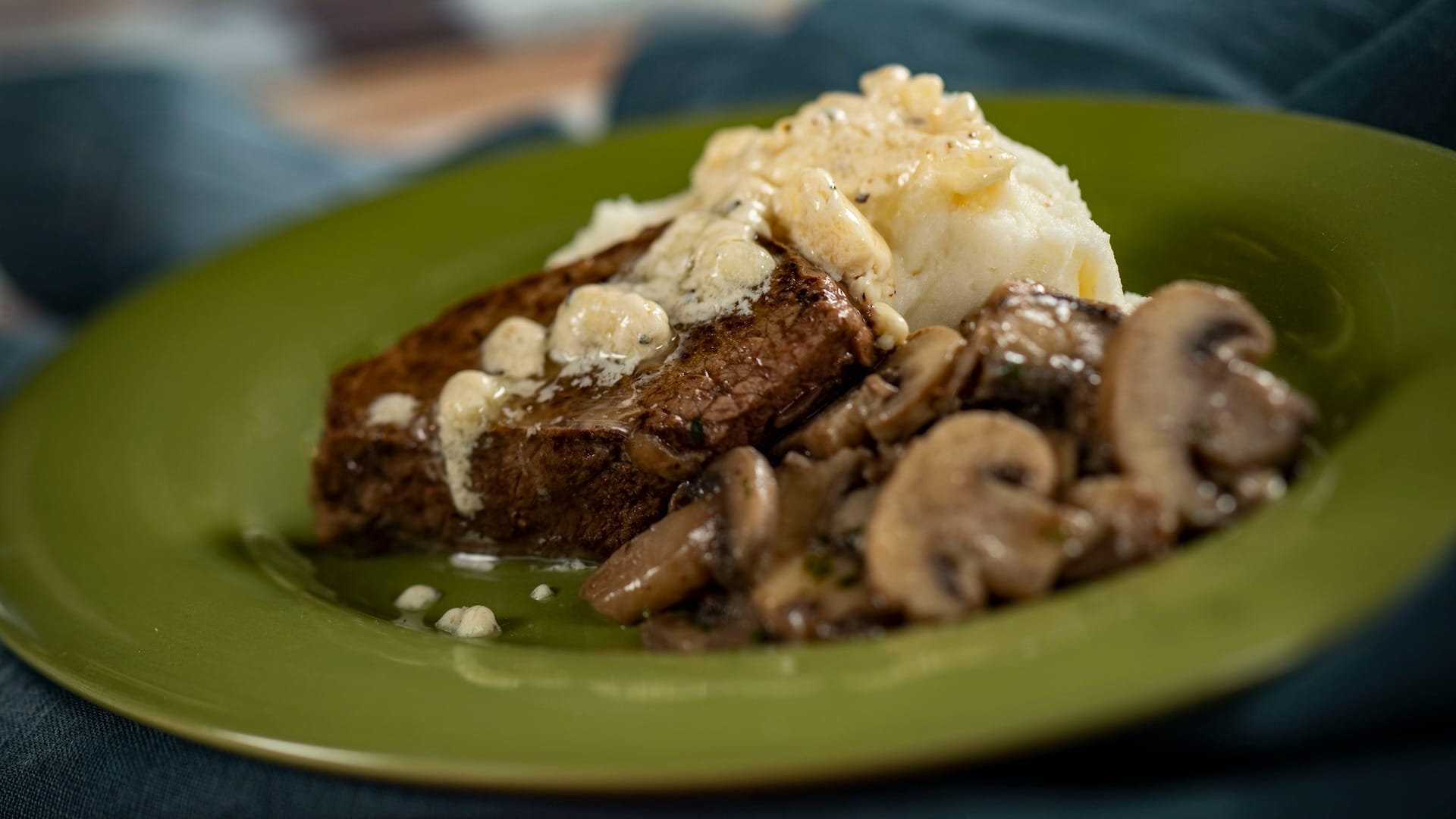 A plate with steak, sautéed mushrooms, and mashed potatoes—perfect for any 2025 menus or food festival.