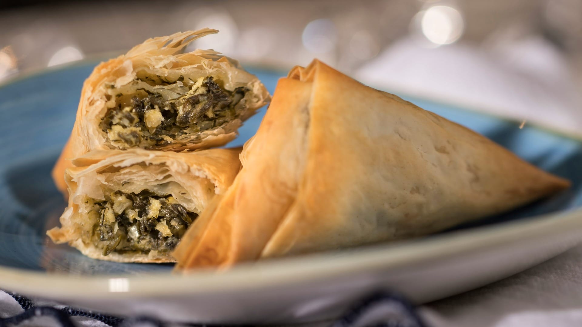 Two golden, flaky spinach and cheese pastries featured on the 2025 menus at the EPCOT Food & Wine Festival.