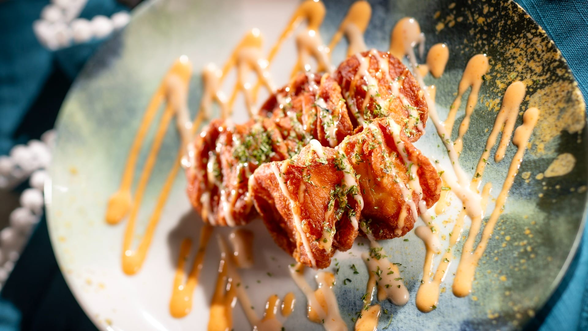Golden, saucy chicken pieces garnished with herbs, inspired by the 2025 EPCOT Food & Wine Festival menus.