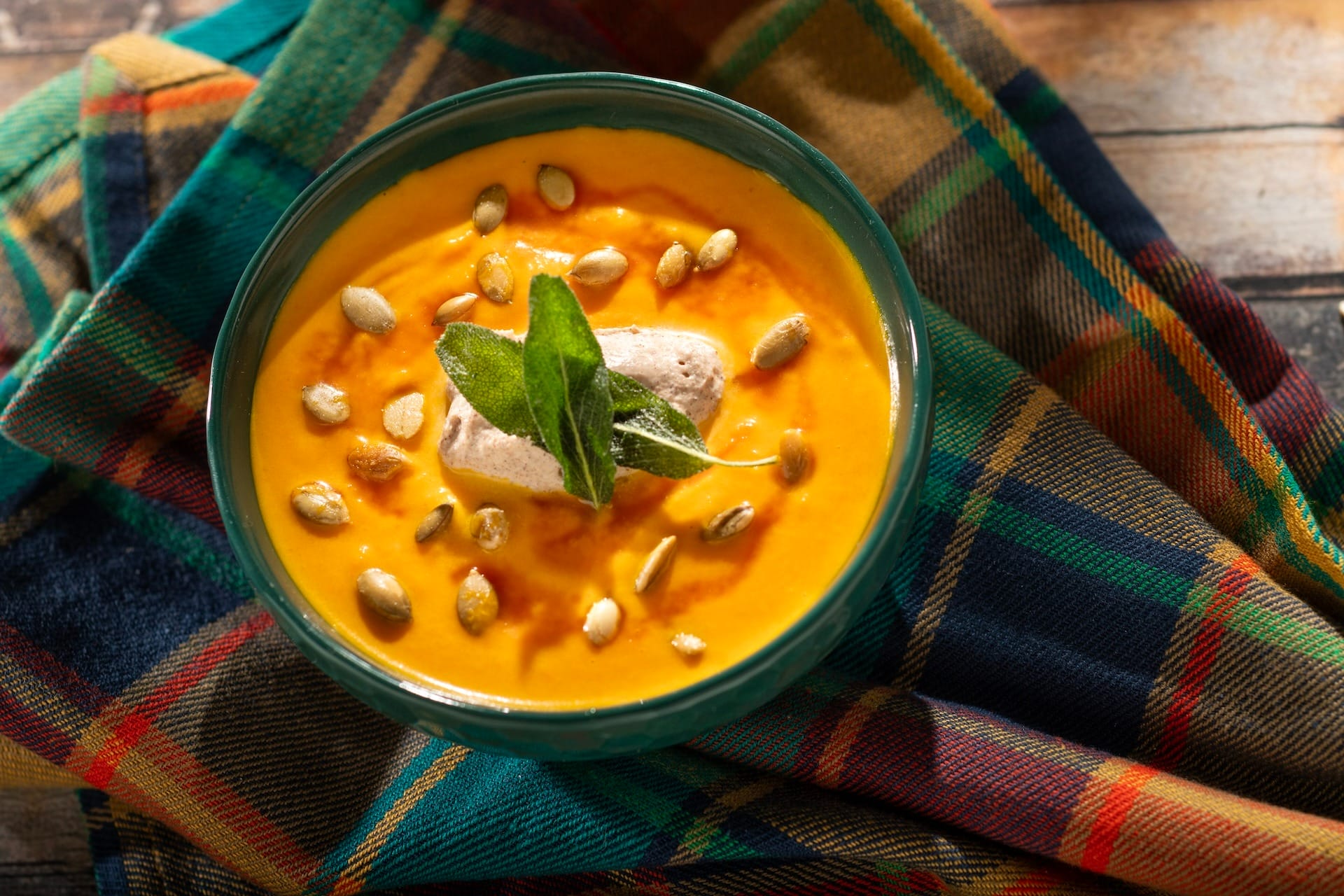 A bowl of creamy orange soup, perfect for 2025 menus or inspired by the EPCOT Food & Wine Festival.