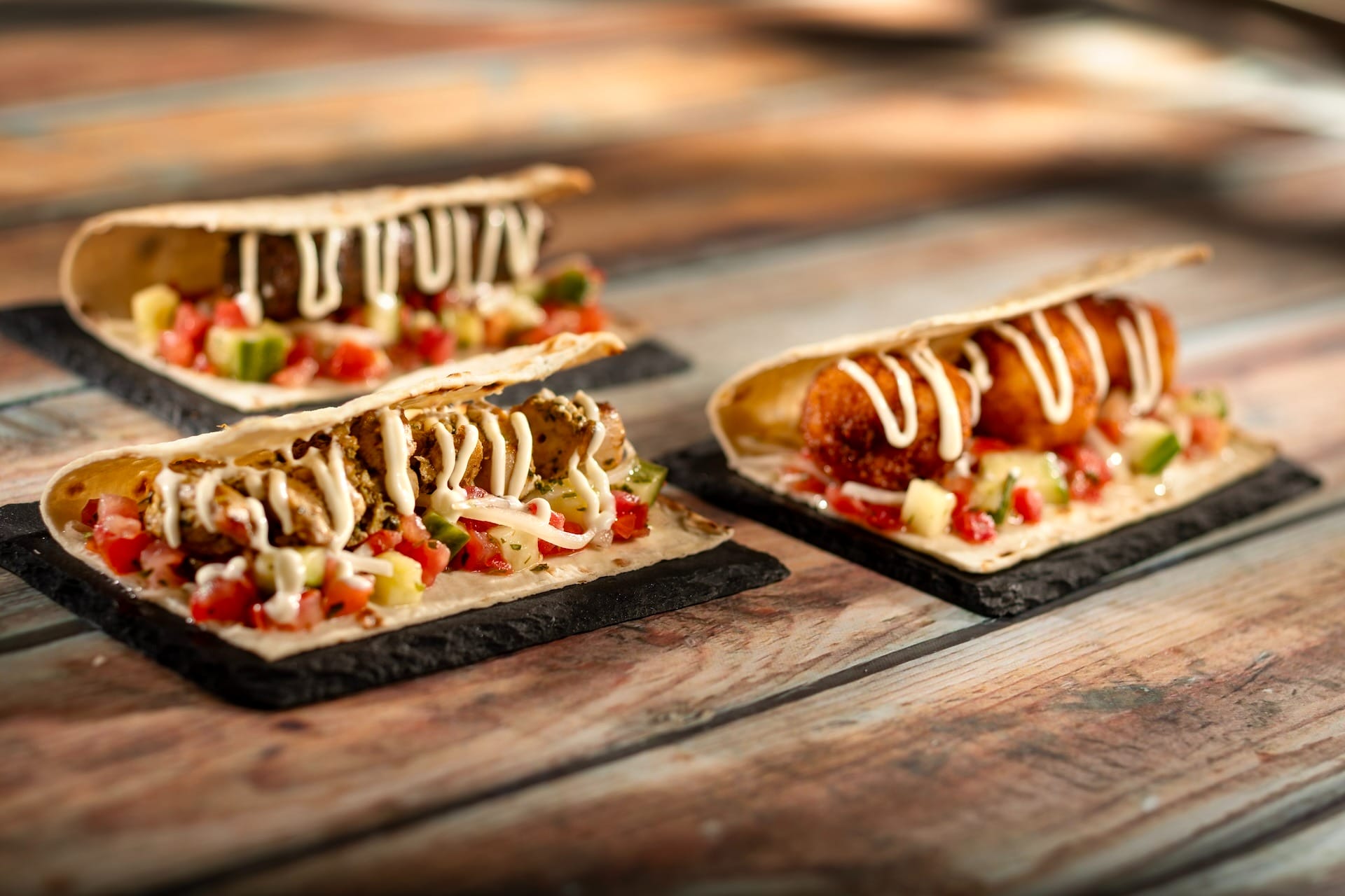 Three gourmet tacos with colorful toppings and creamy drizzle, inspired by EPCOT Food & Wine Festival 2025 menus.
