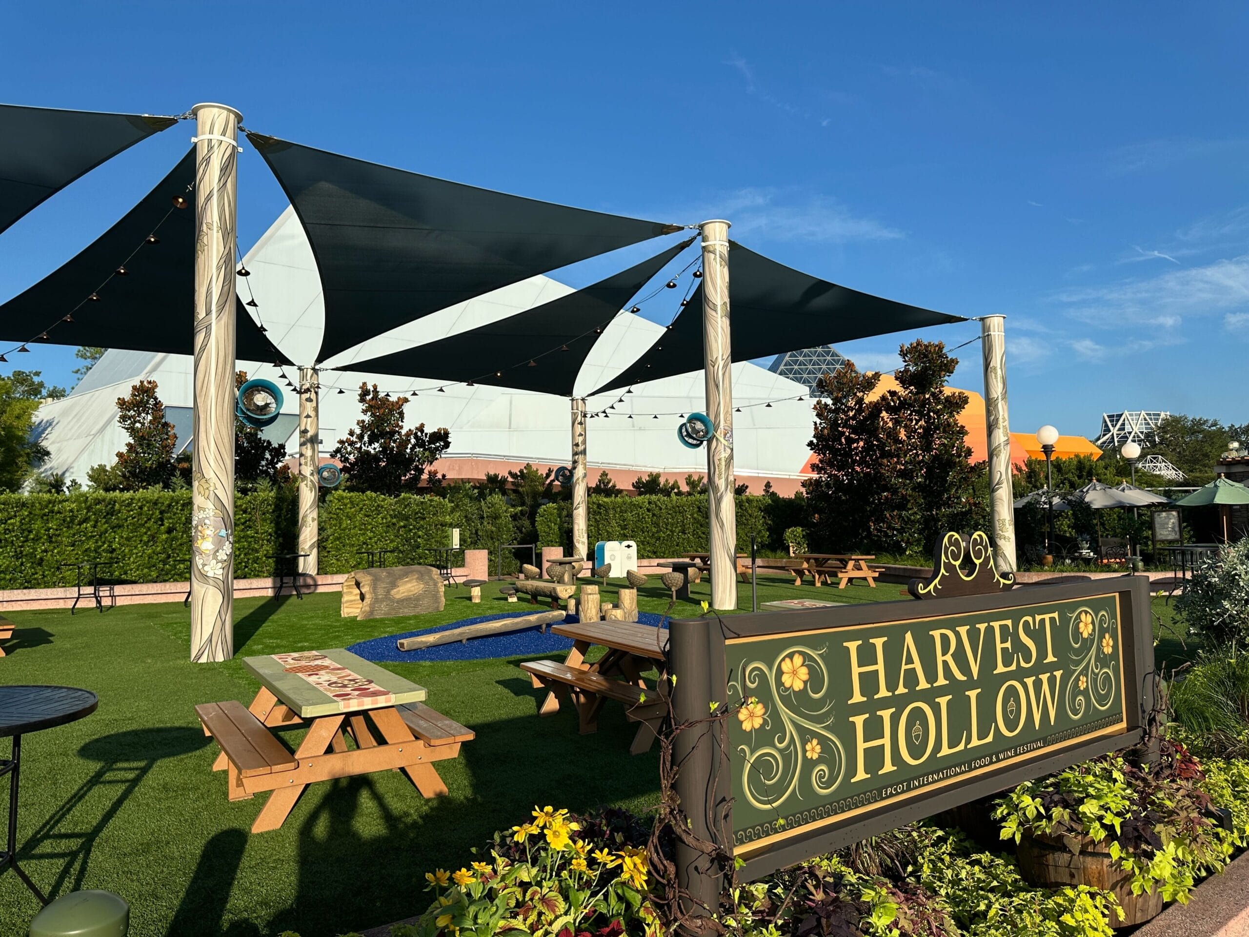 Harvest Hollow Playground with picnic tables, mini-golf, and shade sails at the 2025 EPCOT International Food & Wine Festival.