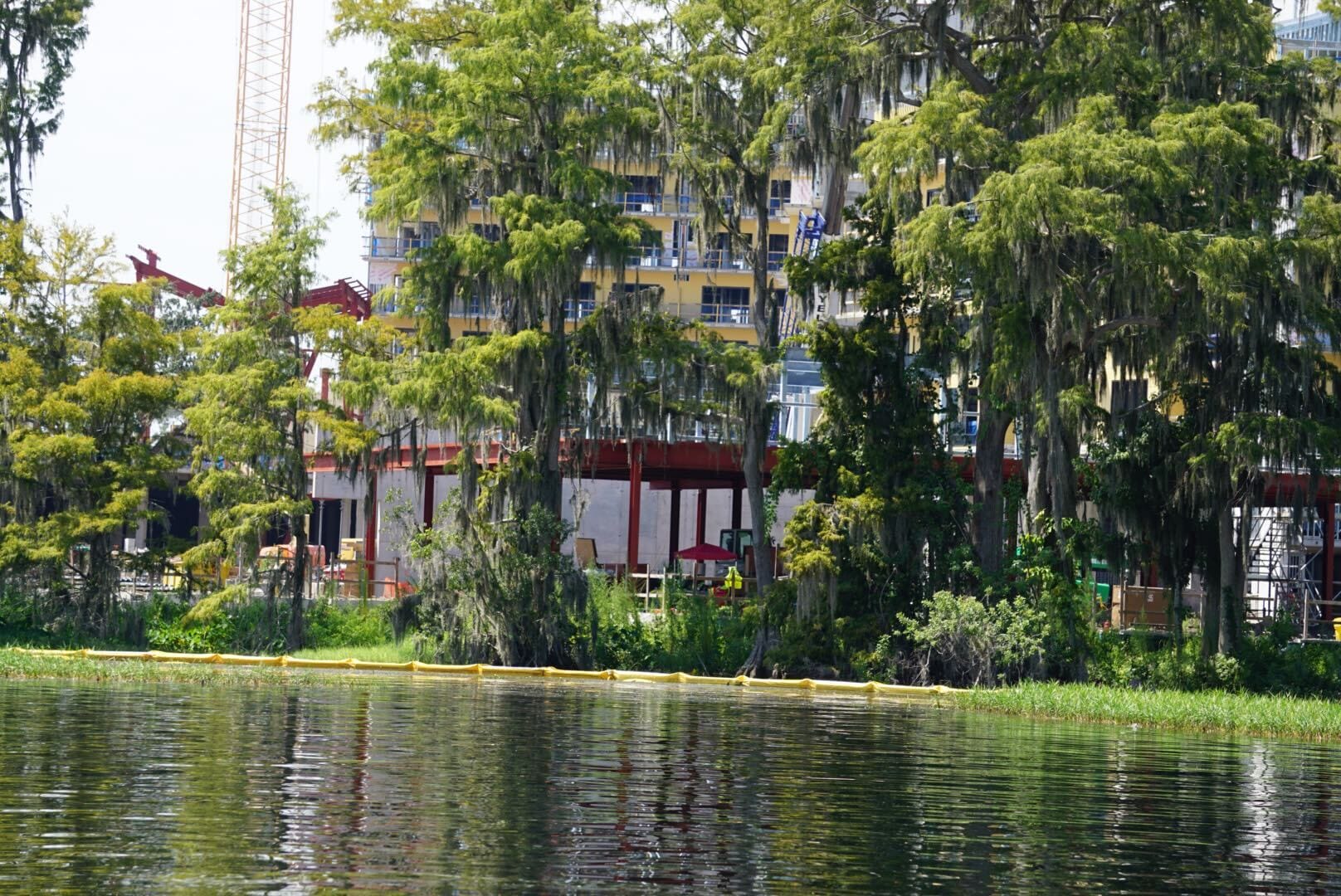 Tall trees with hanging moss line the lake, with a Lakeshore Update showing construction and a new building in the background.