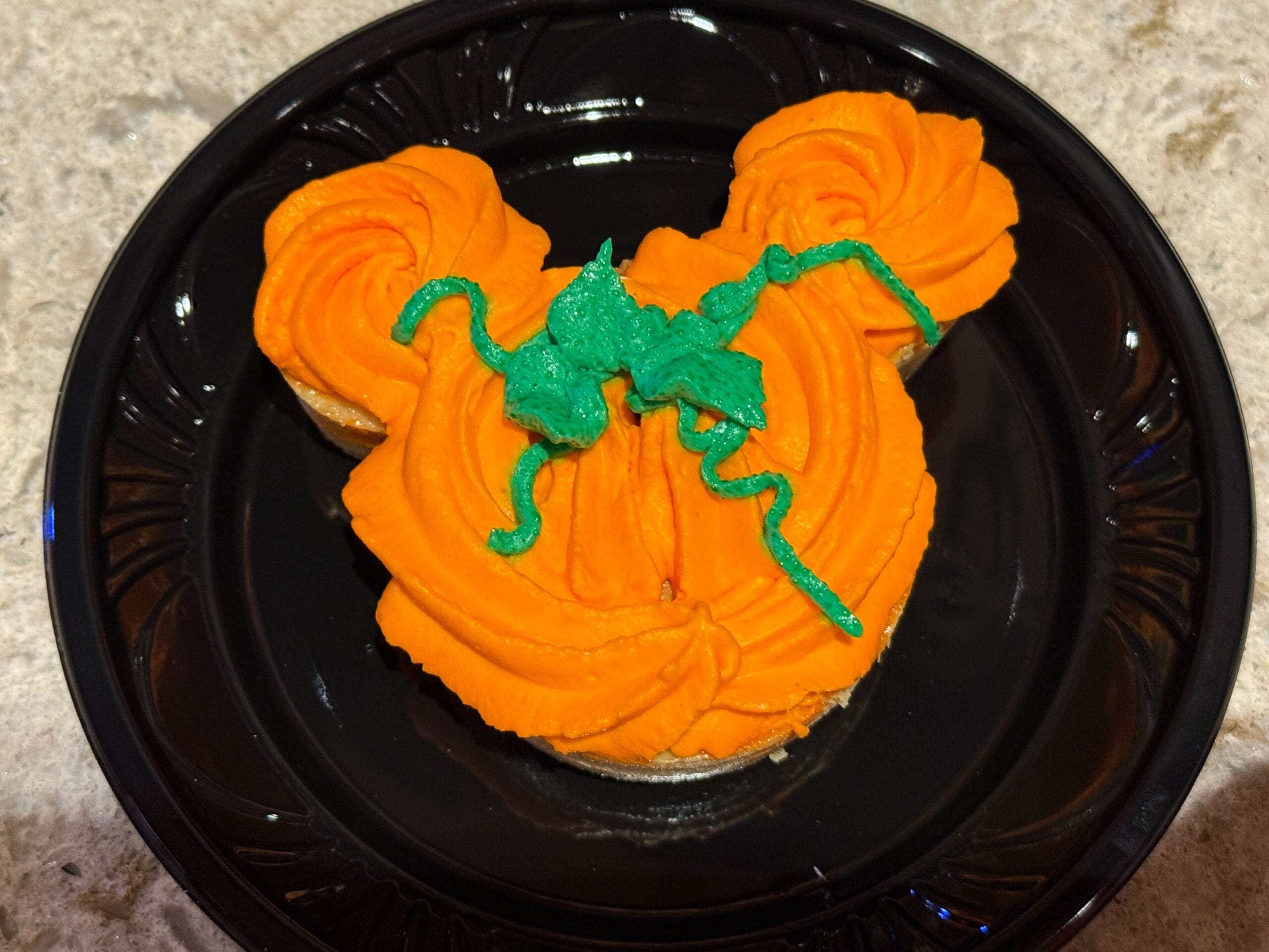 Cupcake shaped like Mickey Mouse, decorated as a pumpkin—perfect for food reviews at Mickey's Not So Scary Halloween Party.