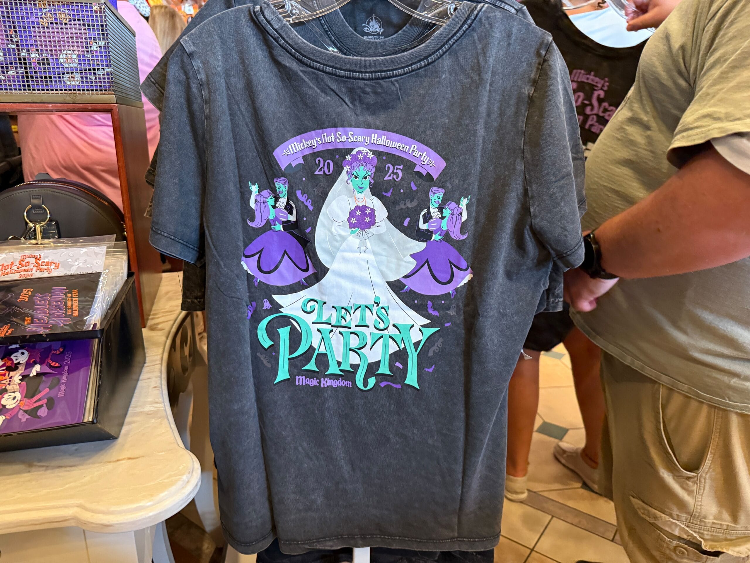 Gray t-shirt featuring a ghost bride and purple ghosts, perfect 2025 merchandise for Mickey's Not So Scary Halloween Party.
