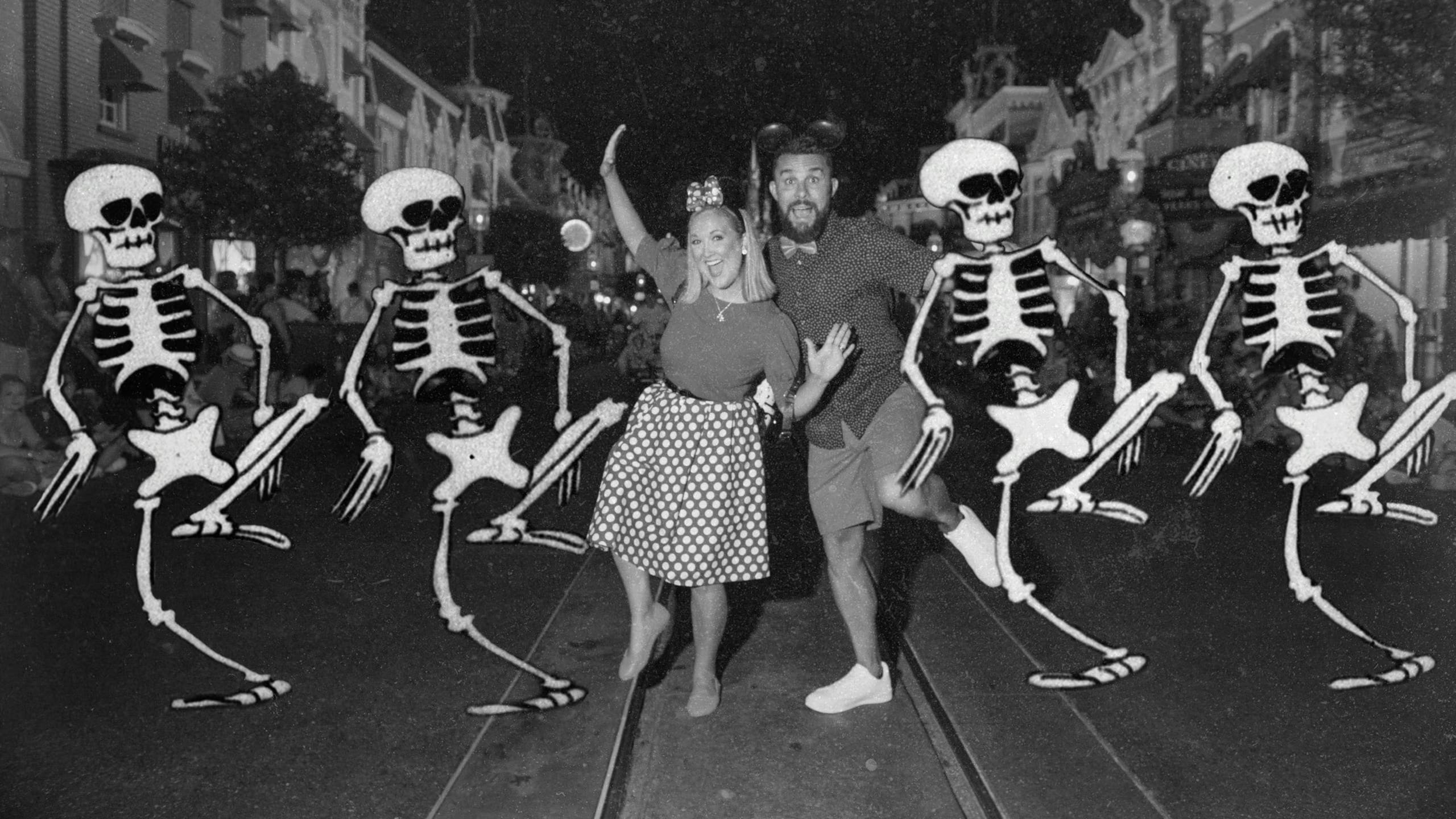 A woman and man pose playfully with five cartoon skeletons using Magic Shots on a city street at night.