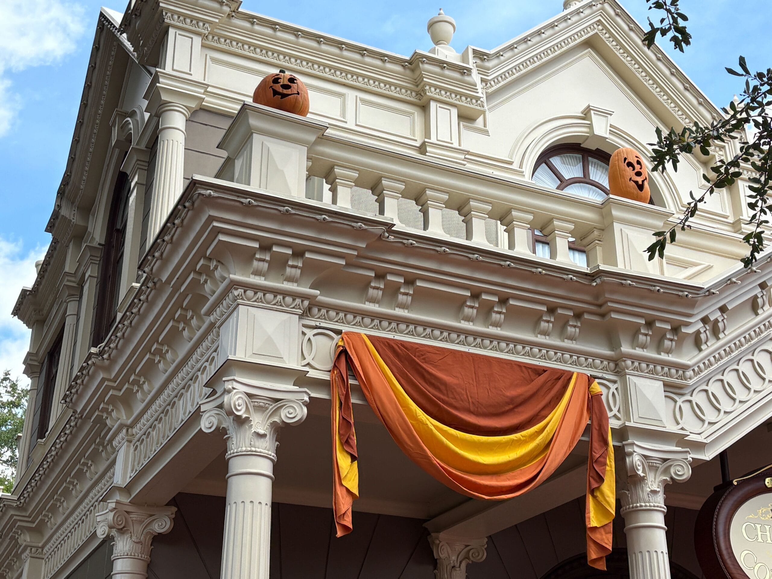 A building adorned with Halloween decor and jack-o'-lanterns, resembling Magic Kingdom’s festive spirit.