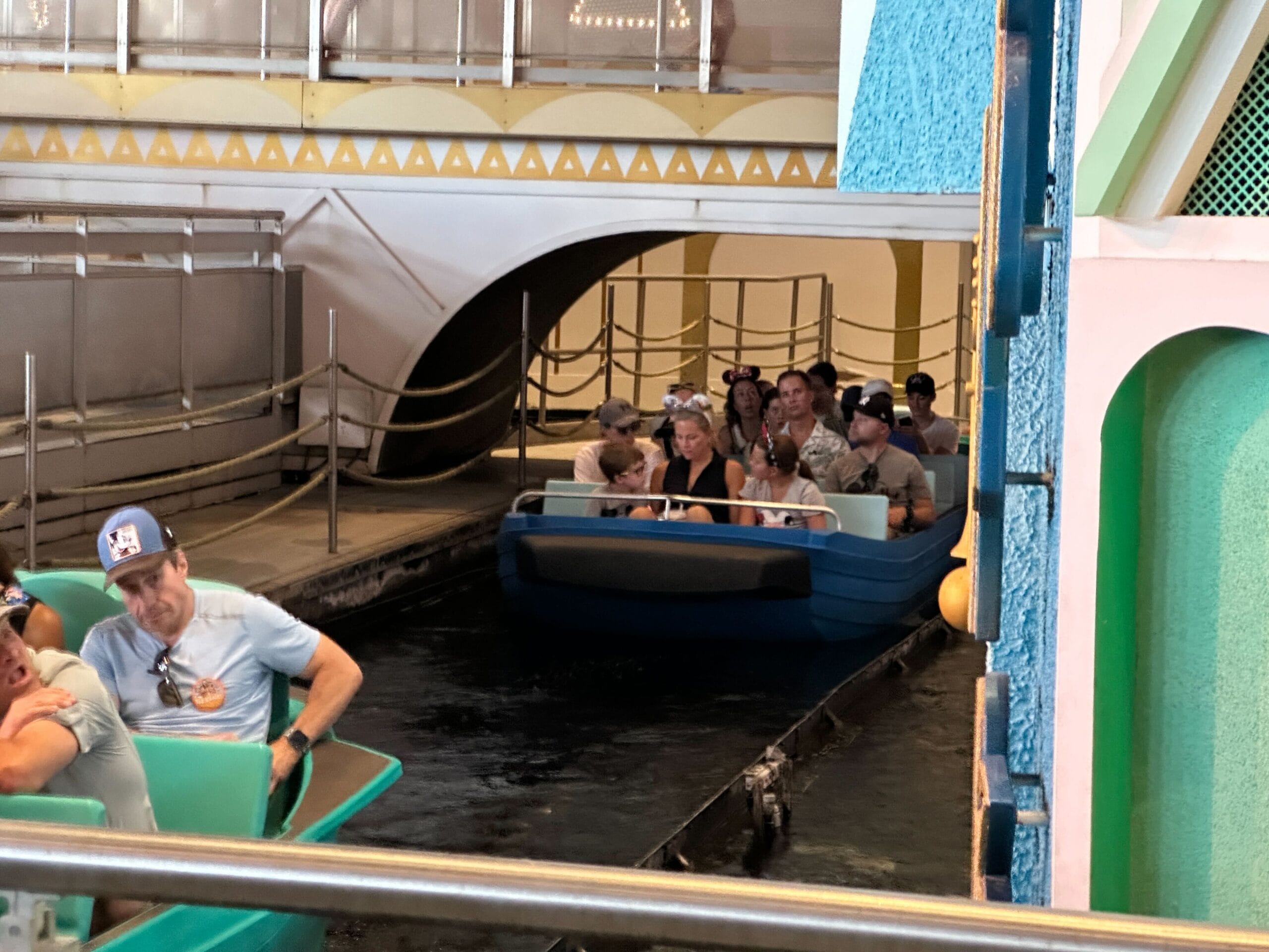 People ride new boats in Magic Kingdom’s "it’s a small world," gliding under a decorative arch on the indoor water ride.