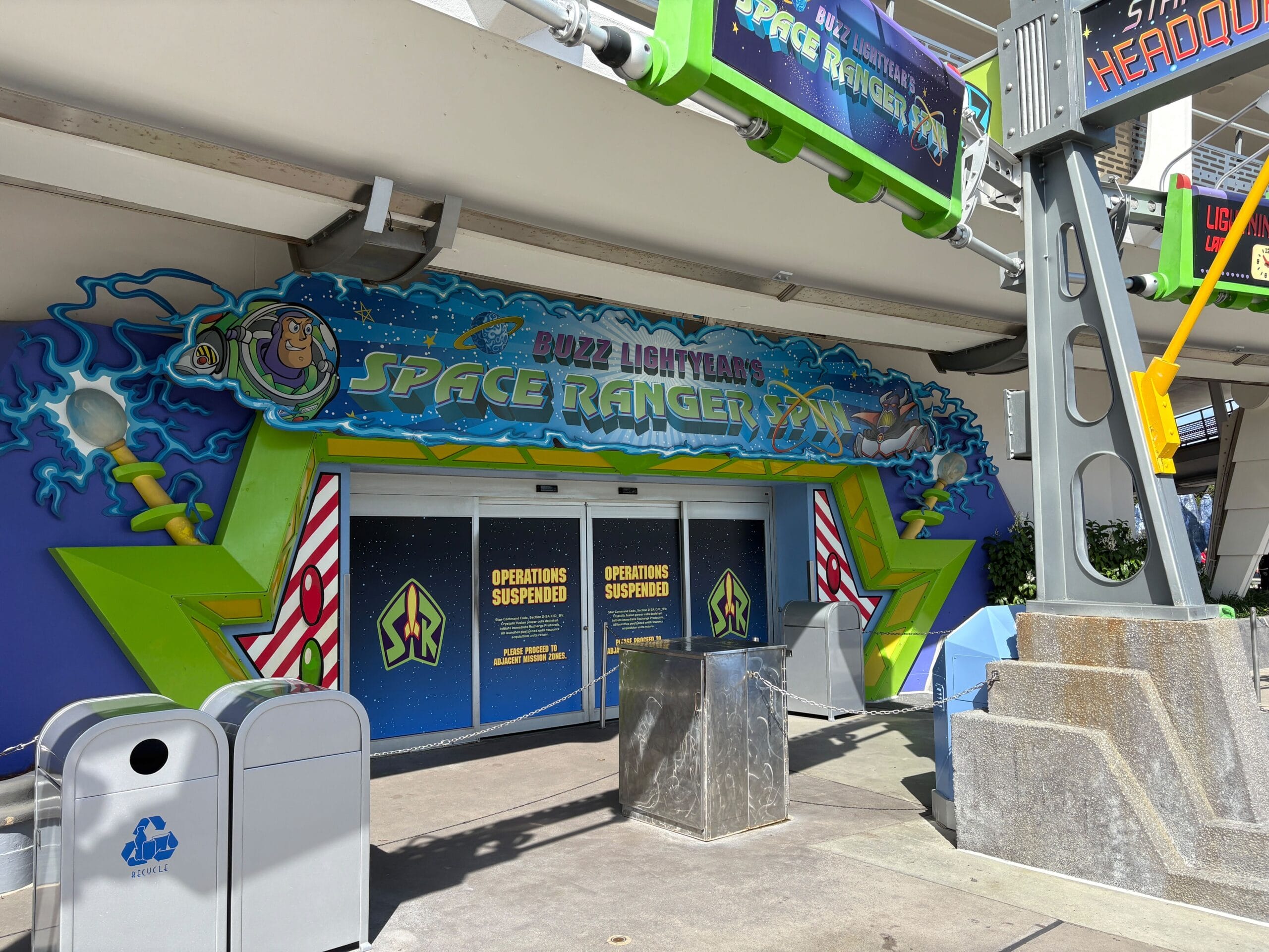 Entrance to Buzz Lightyear's Space Ranger Spin ride with signs reading "Operations Suspended," at a theme park.