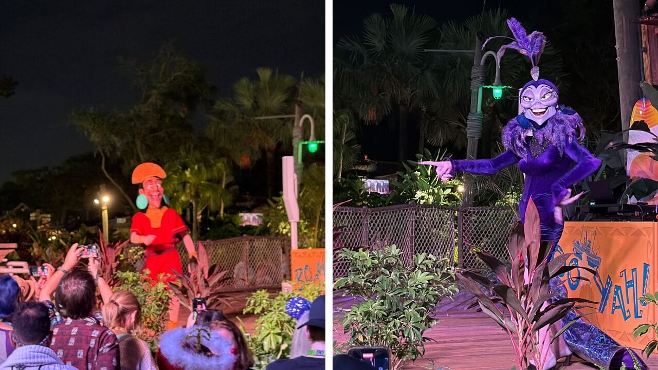 Two costumed performers entertain a crowd at an outdoor night event with tropical plants and palm trees in the background.
