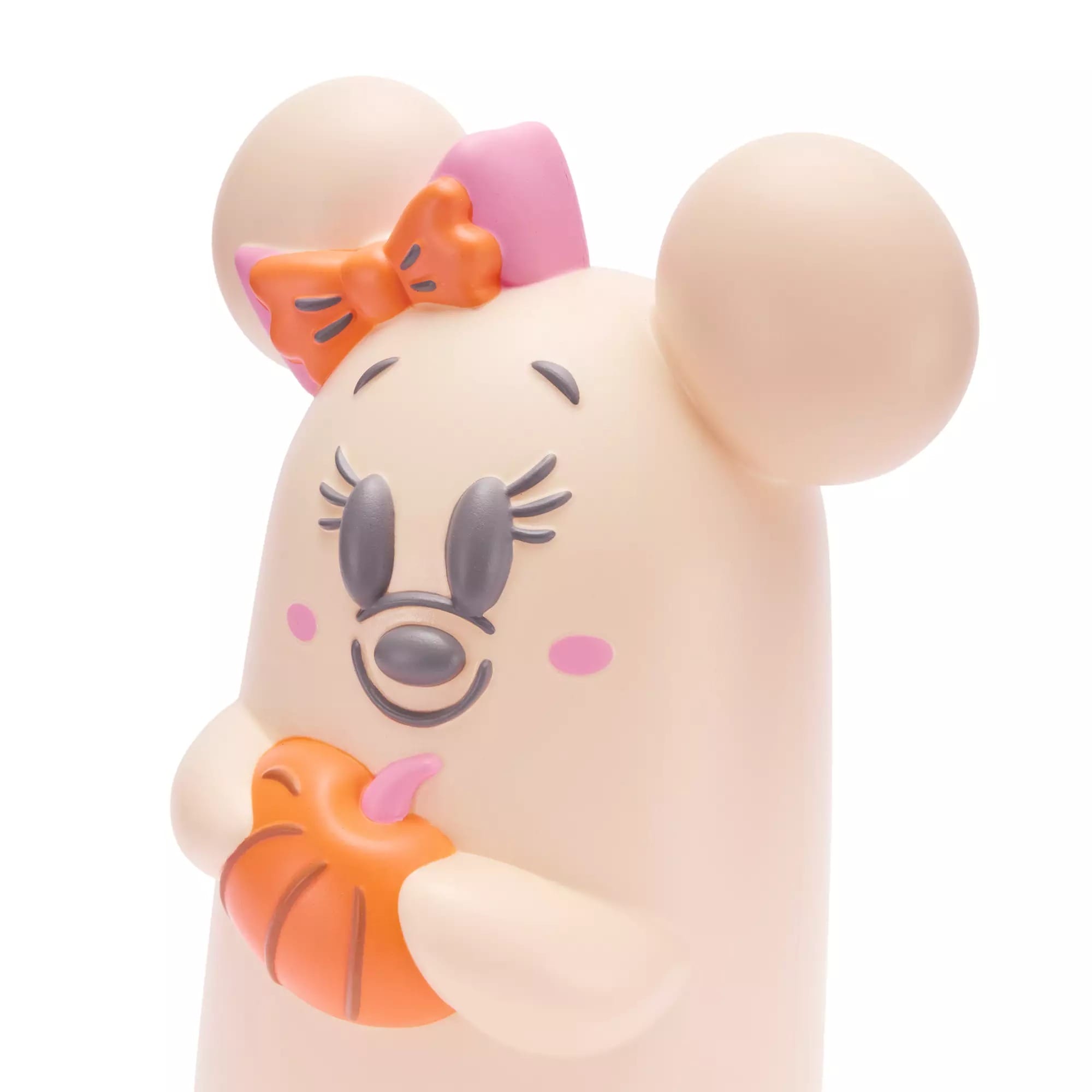 Cartoon mouse figurine with a pink bow, long lashes, and holding an orange pumpkin, on a white background.