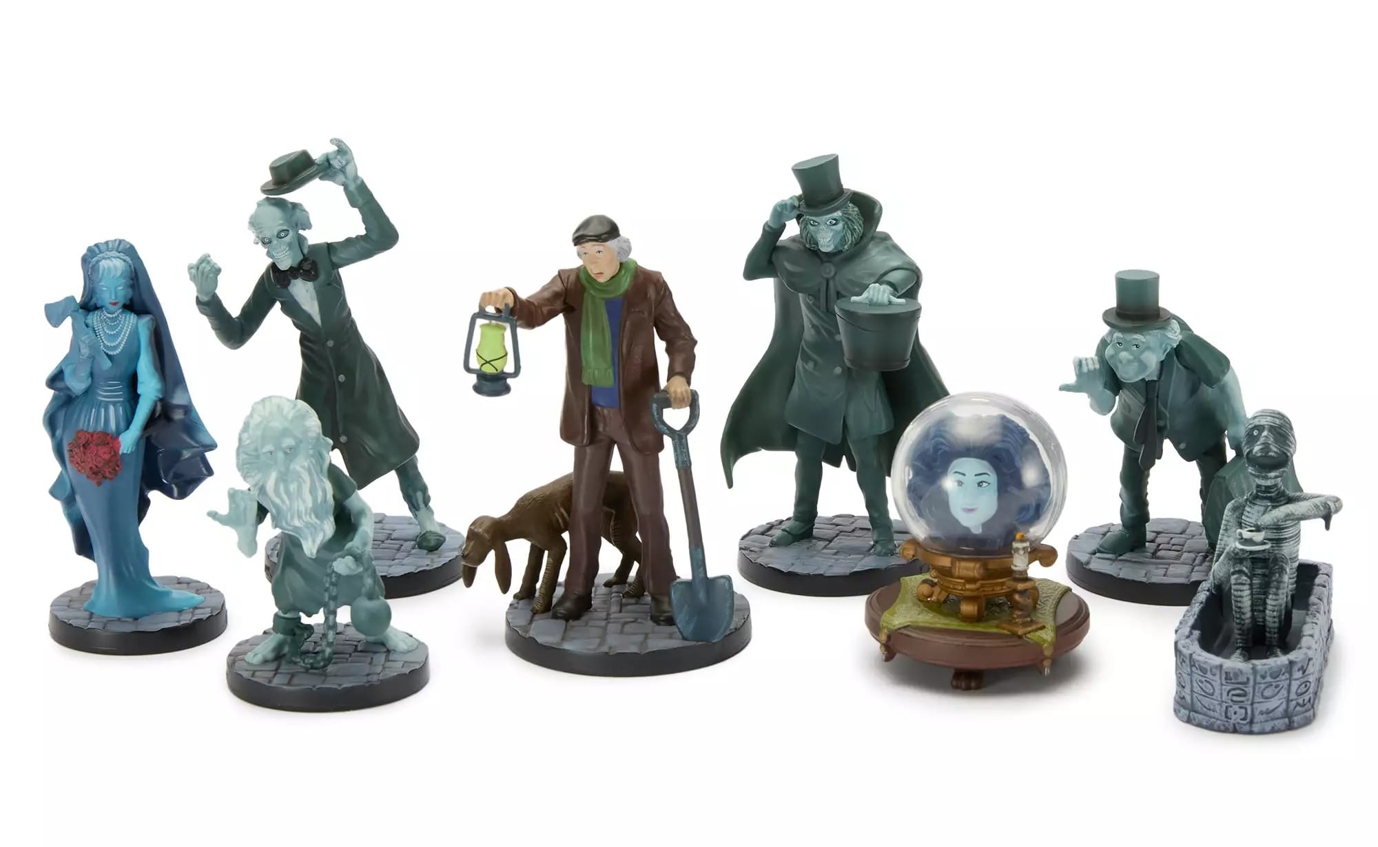 Eight Haunted Mansion figurines, including ghosts, a caretaker with a dog, and Madame Leota in her crystal ball.