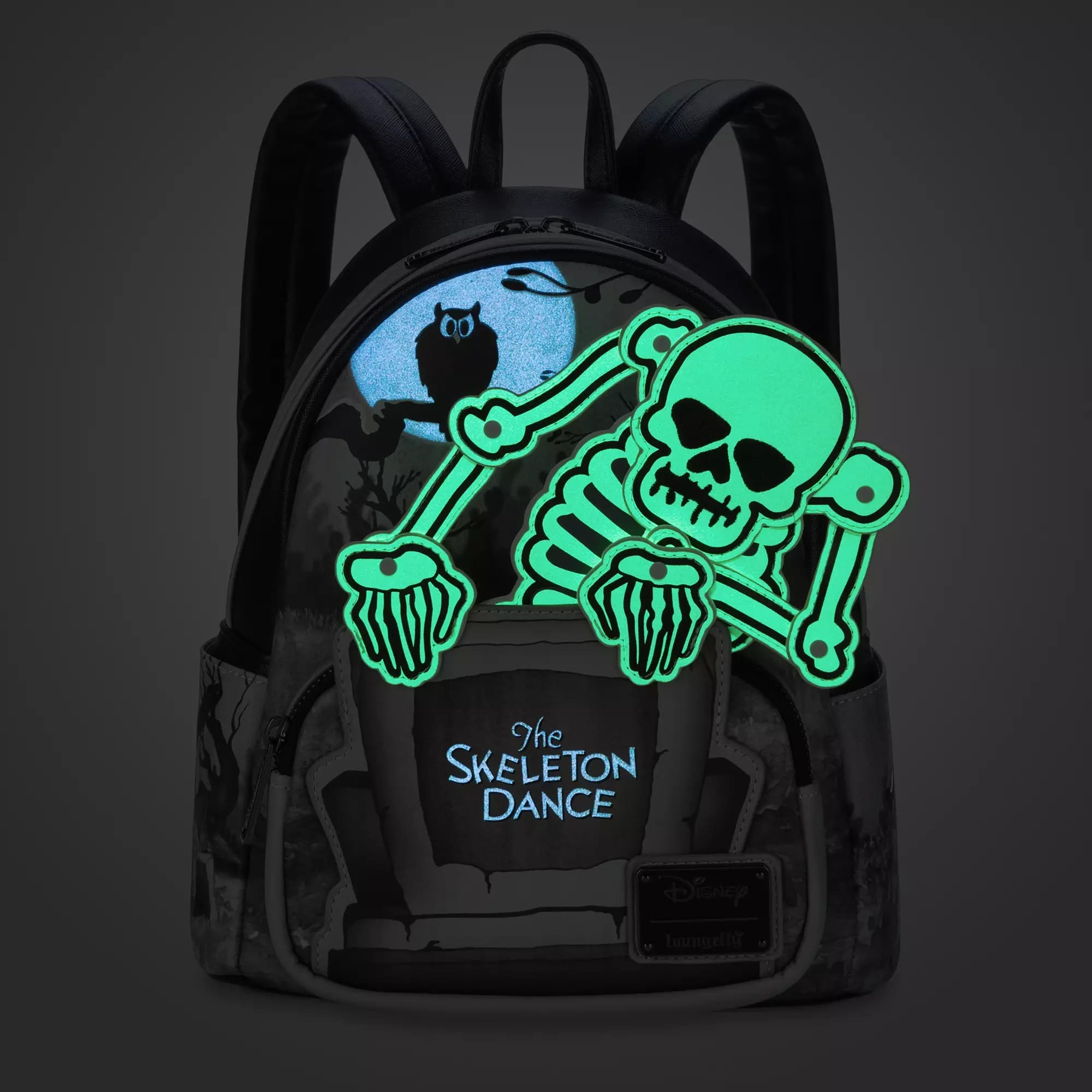 Disney Store Skeleton Dance Backpack with owl and tombstone design, features glow-in-the-dark Loungefly skeleton accents.