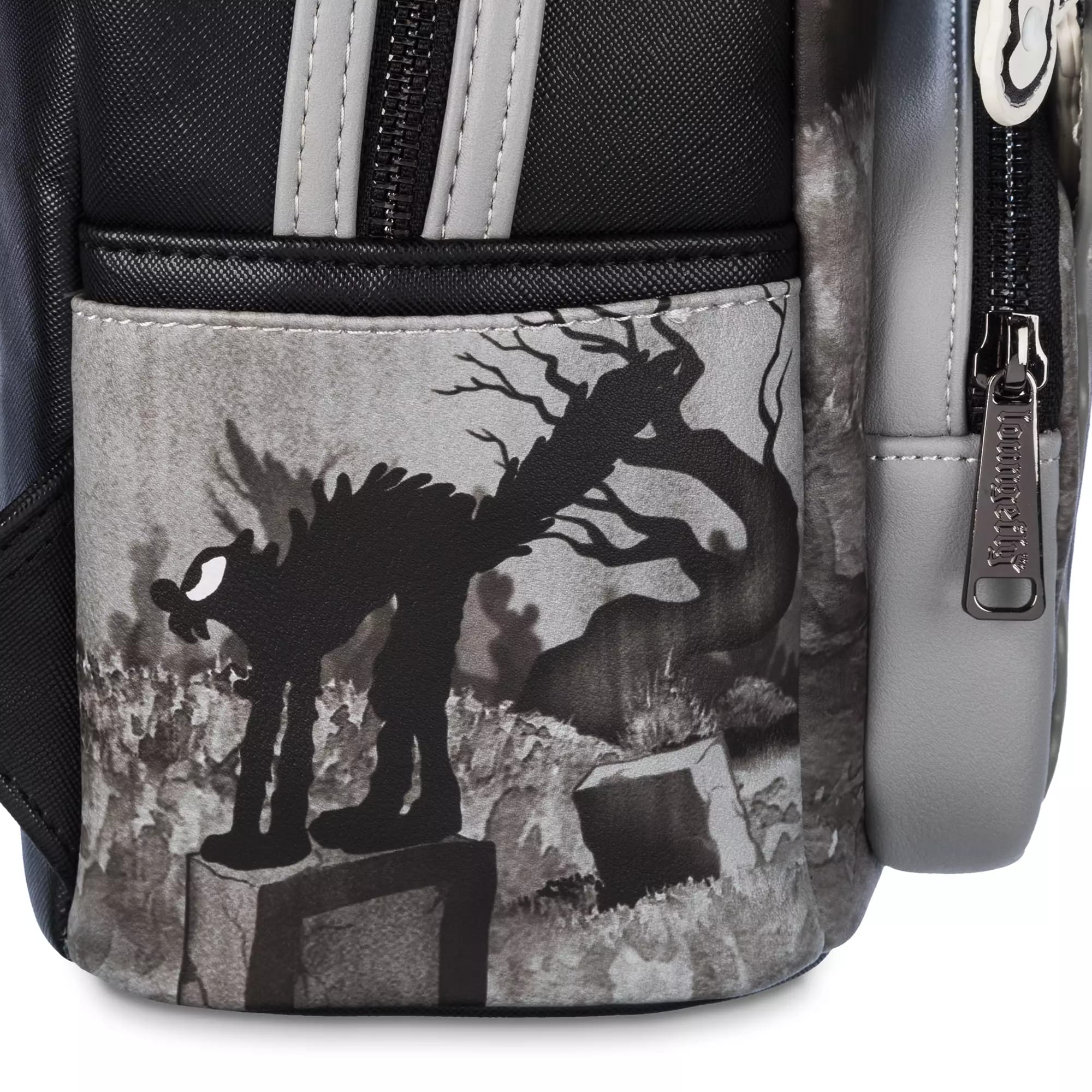 A black-and-white cartoon cat stands on a stone, spooky trees behind it—a nod to the Skeleton Dance backpack.
