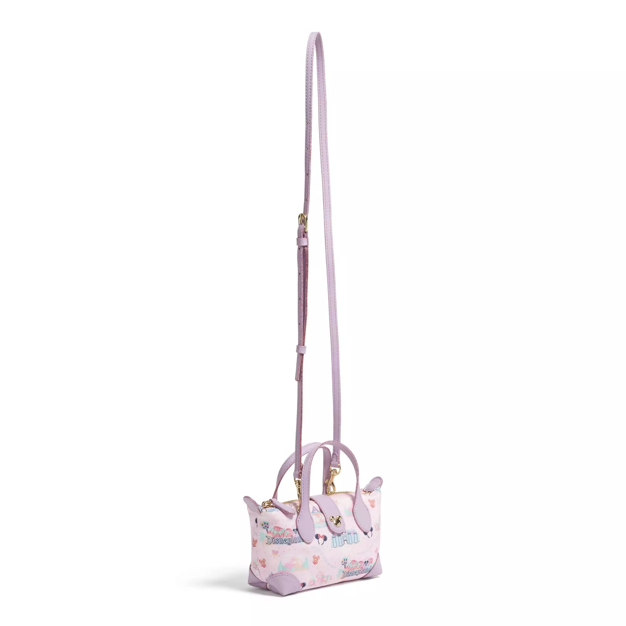 Light pink mini handbag with a long adjustable strap, gold hardware, and a playful pastel print on the body.