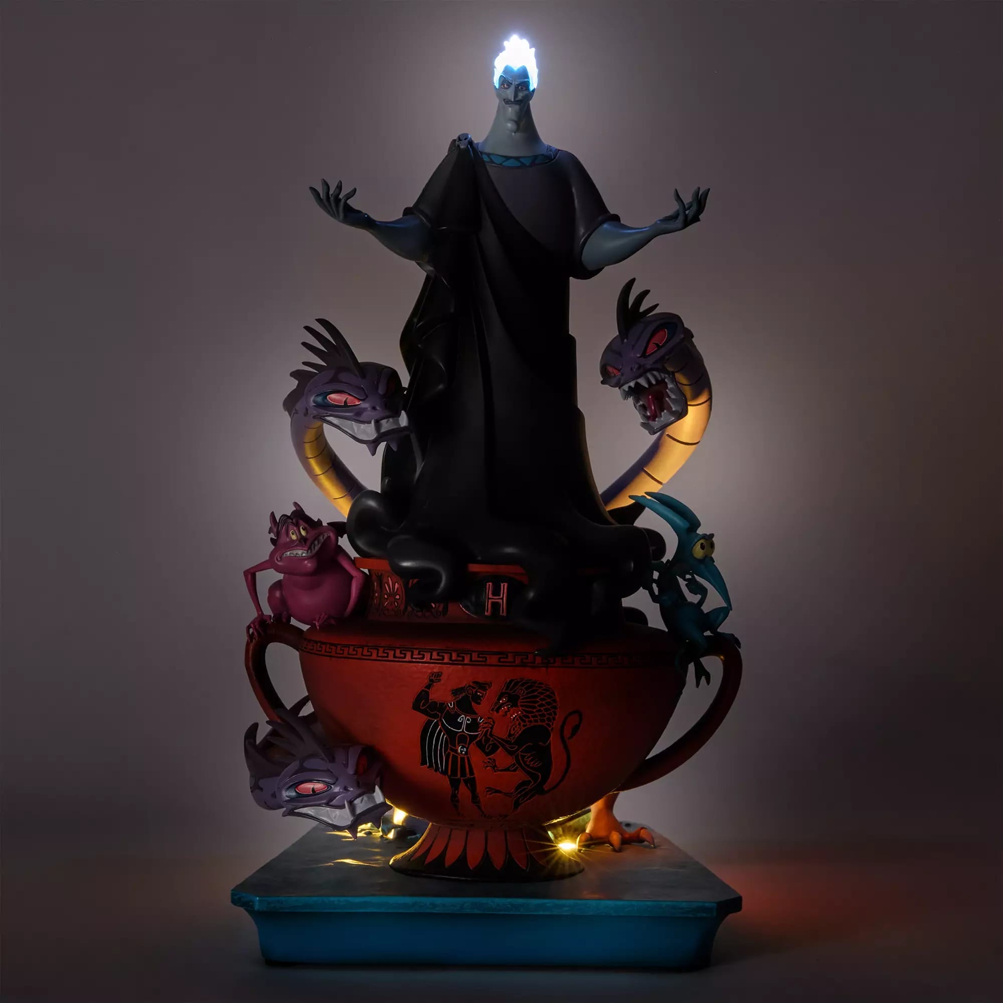 A Disney Villains statue of Hades stands on a red urn with Hydra heads and his minions Pain and Panic.