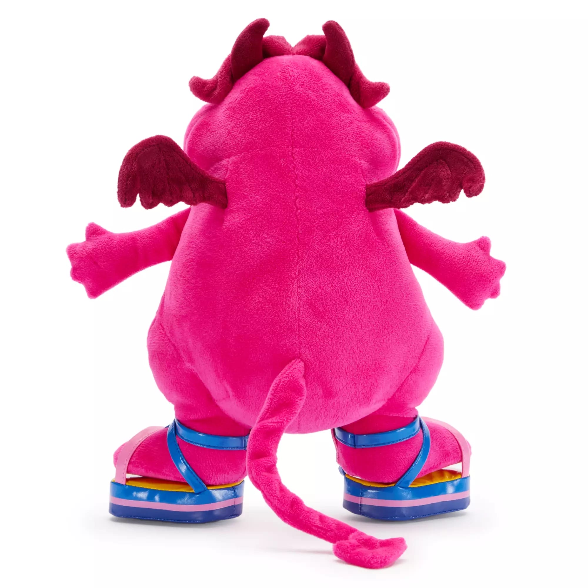 A plush pink creature with wings, horns, and a tail wears Disney Villains platform sandals, seen from behind.