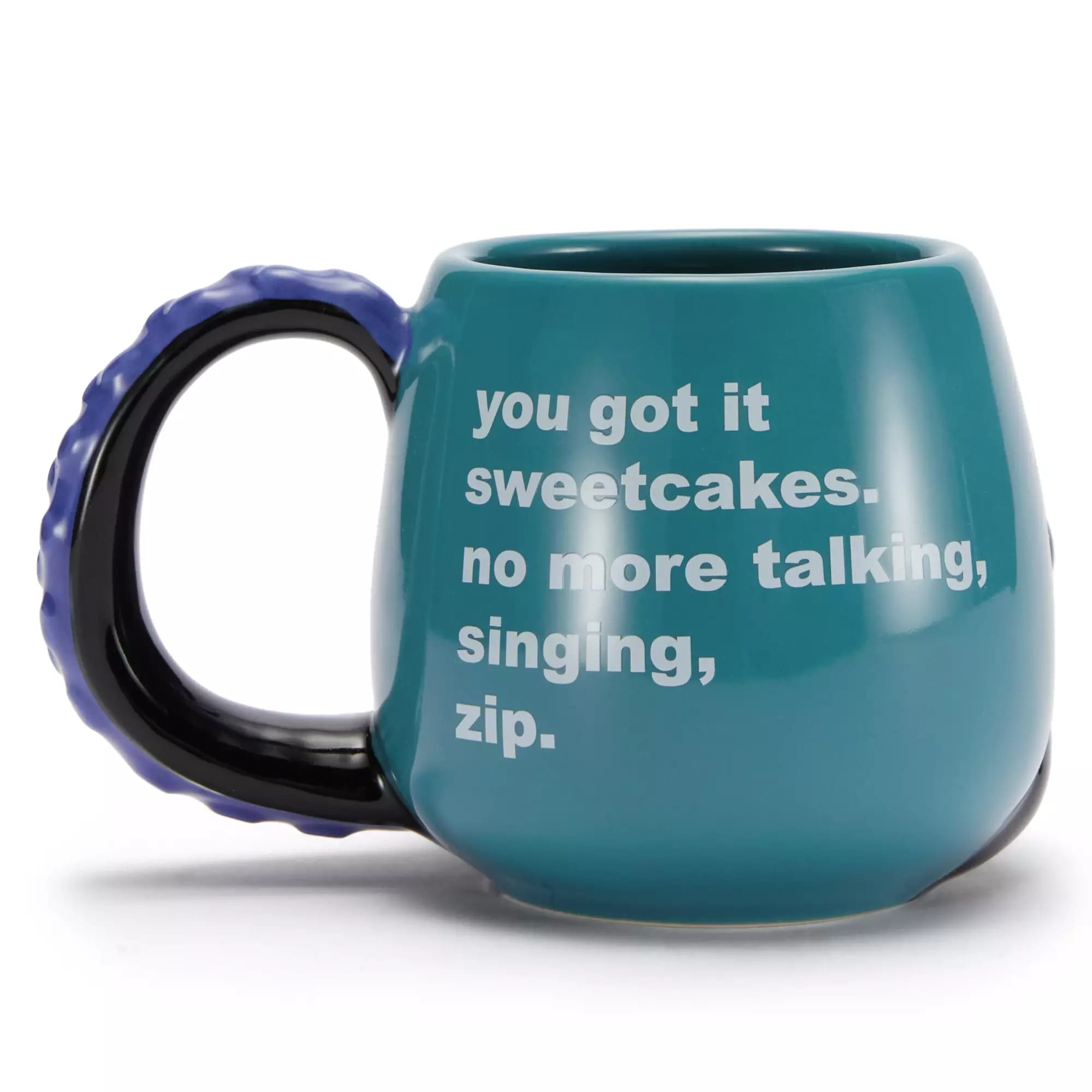 A teal mug with a black handle, part of Disney Villains Merchandise, reads "you got it sweetcakes. no more talking, singing, zip.