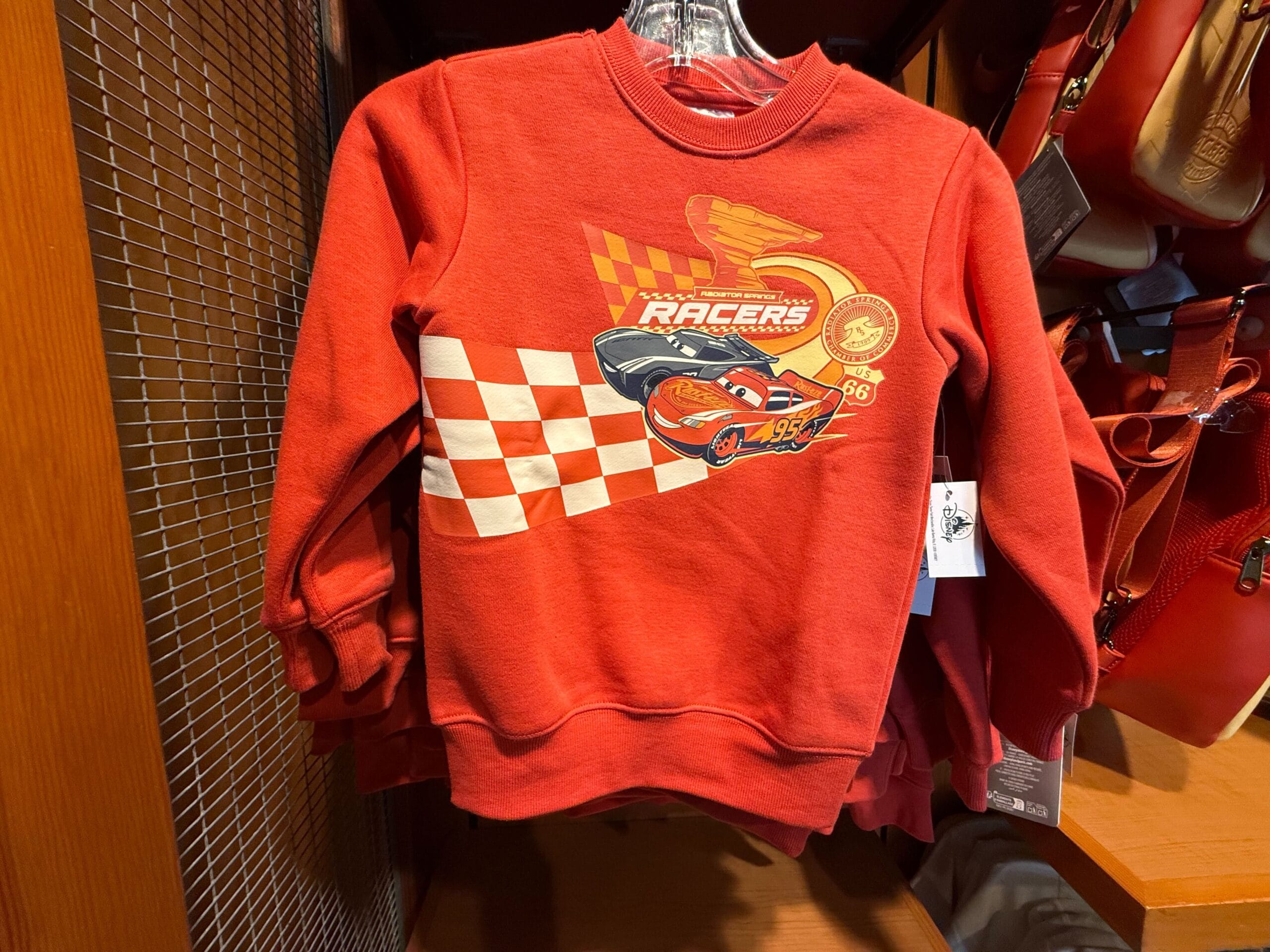 Red children’s sweatshirt featuring Lightning McQueen from Cars, a checkered flag, and "Racers" text on the front.