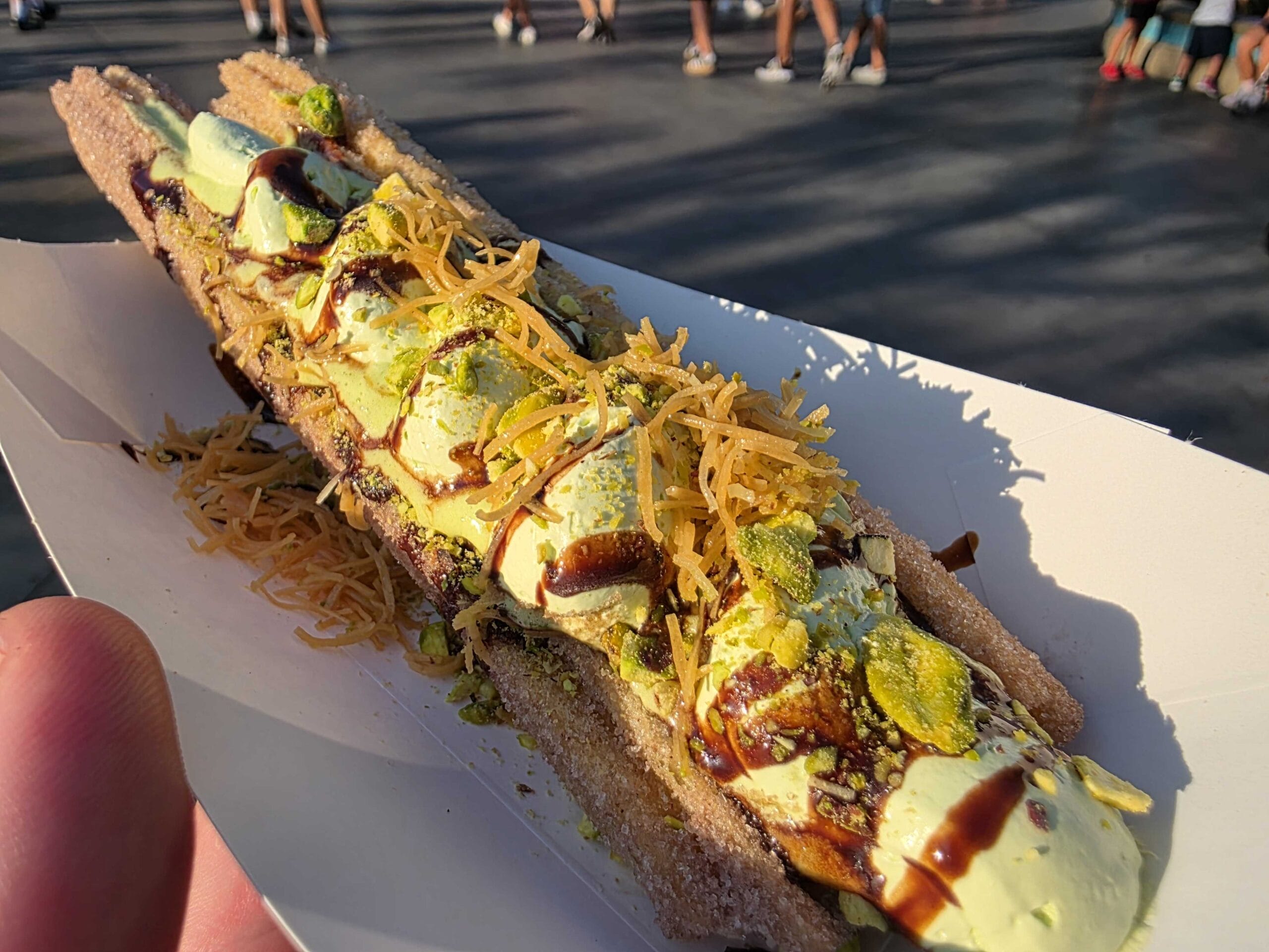 A Celestial Chocolate Churro topped with cream, cheese, sauce, and nuts at Disney California Adventure.