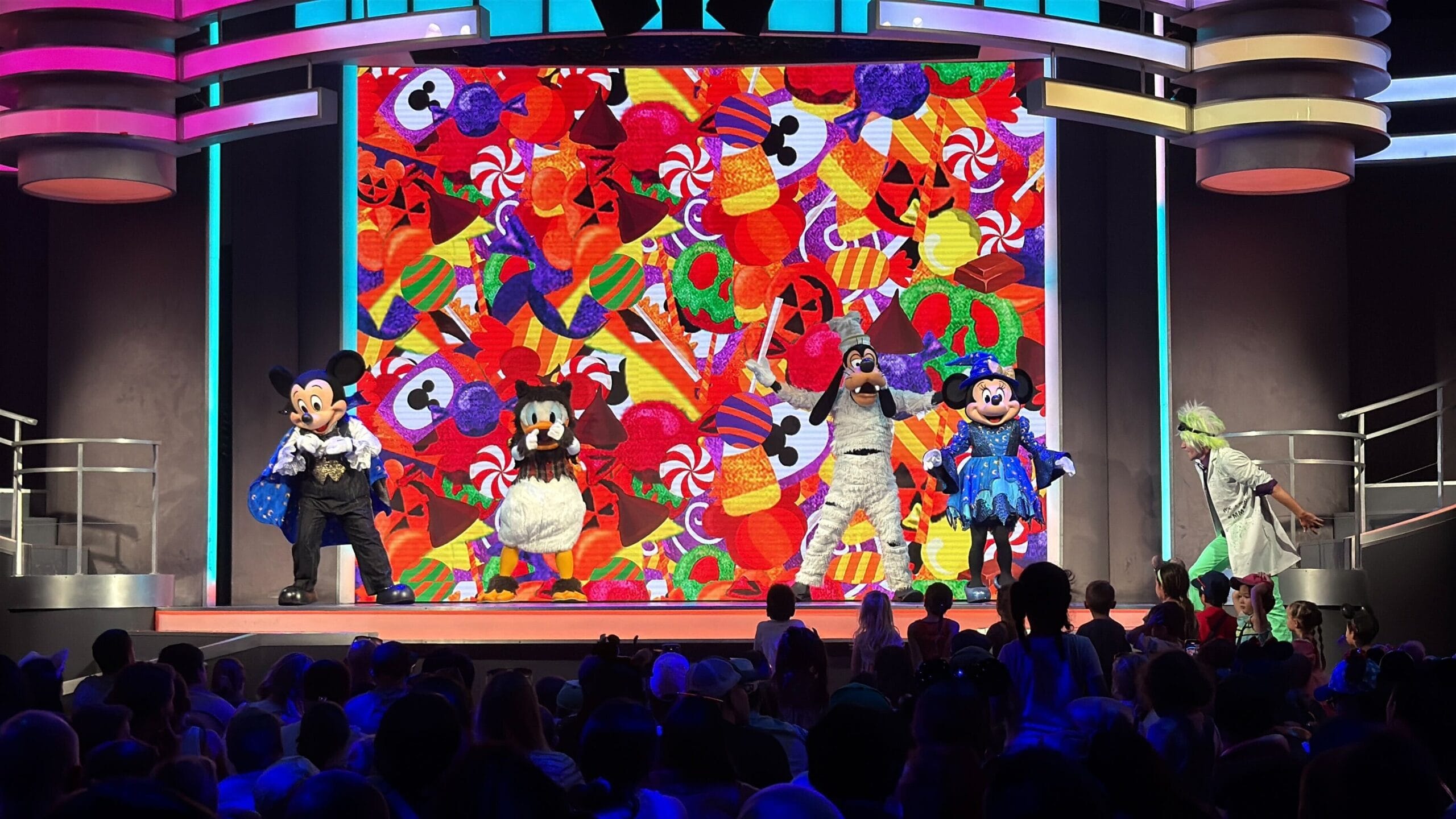 Disney characters perform on stage for Mickey's Trick and Treat, dazzling the audience with a candy-themed Halloween backdrop.