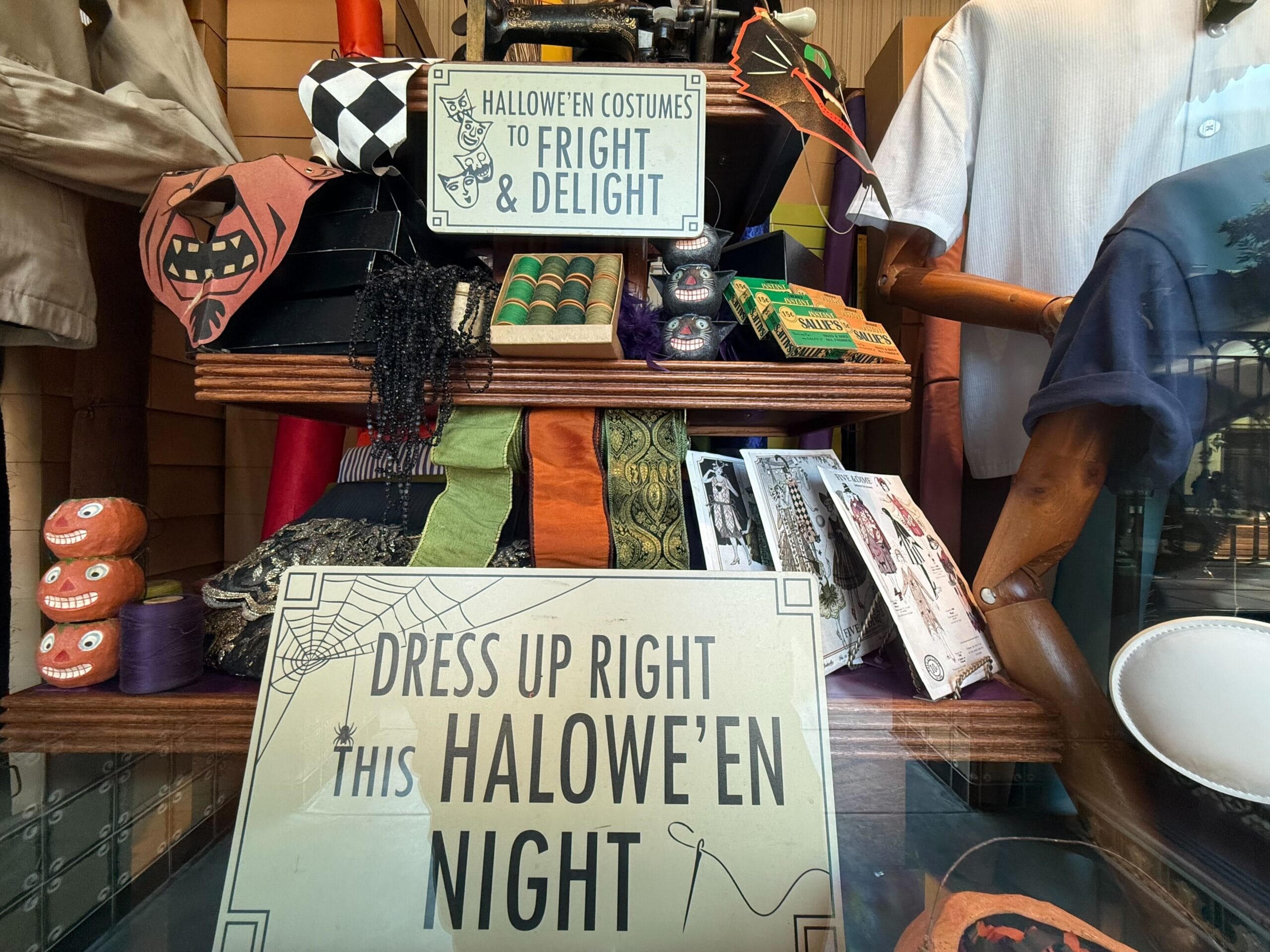 A store display with Halloween costumes, decorations, and signs reading "DRESS UP RIGHT THIS HALOWE'EN NIGHT.