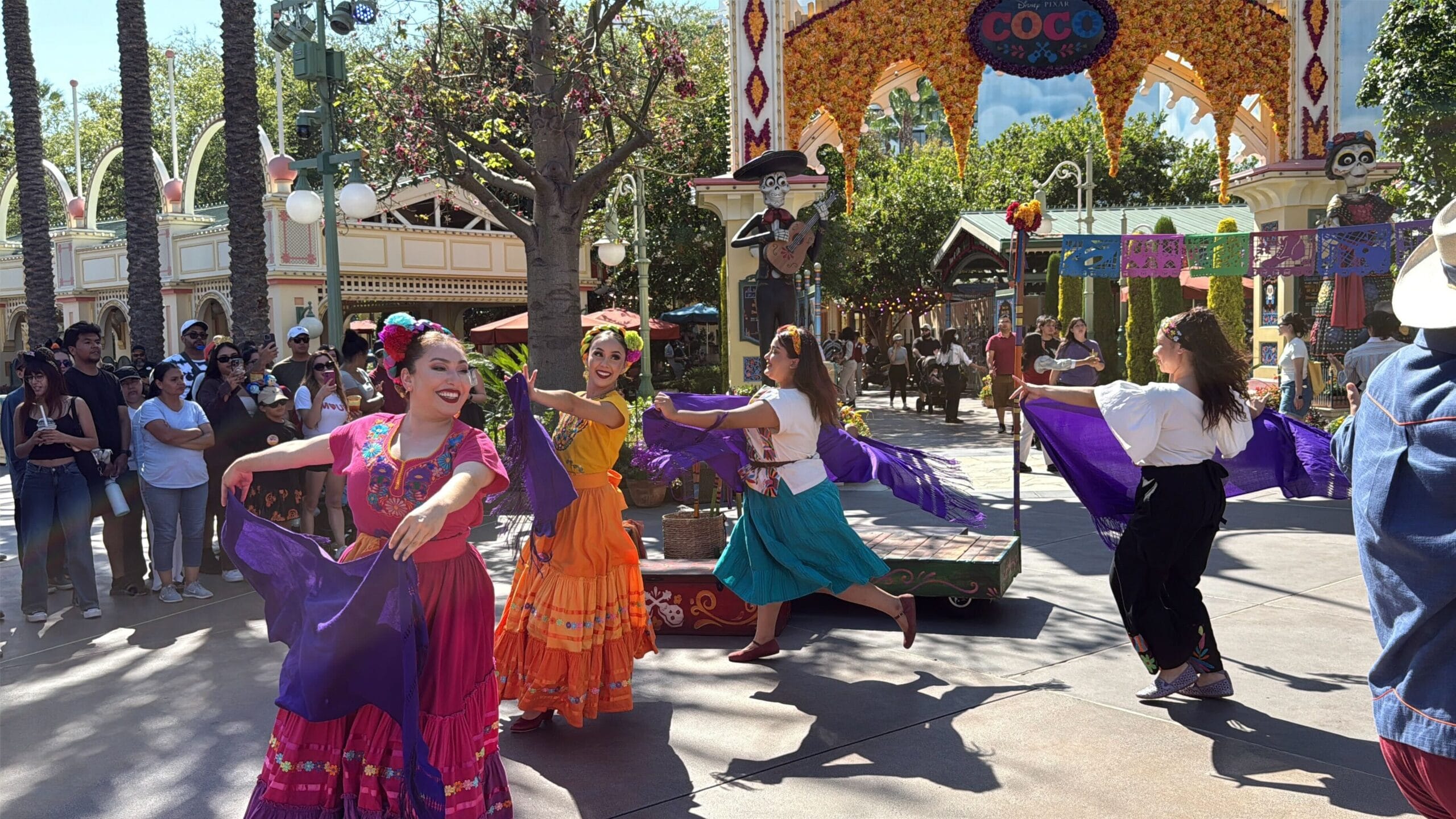 Dancers in colorful costumes perform at Plaza de la Familia during a Coco-themed event at Disney California Adventure.