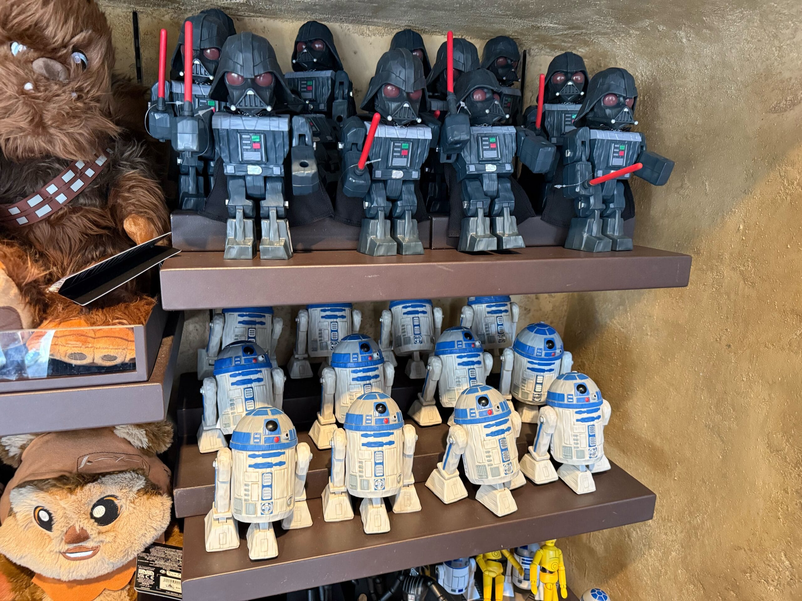 Shelves display Darth Vader and R2-D2 toys, with Chewbacca and Ewok plushies visible on the side.