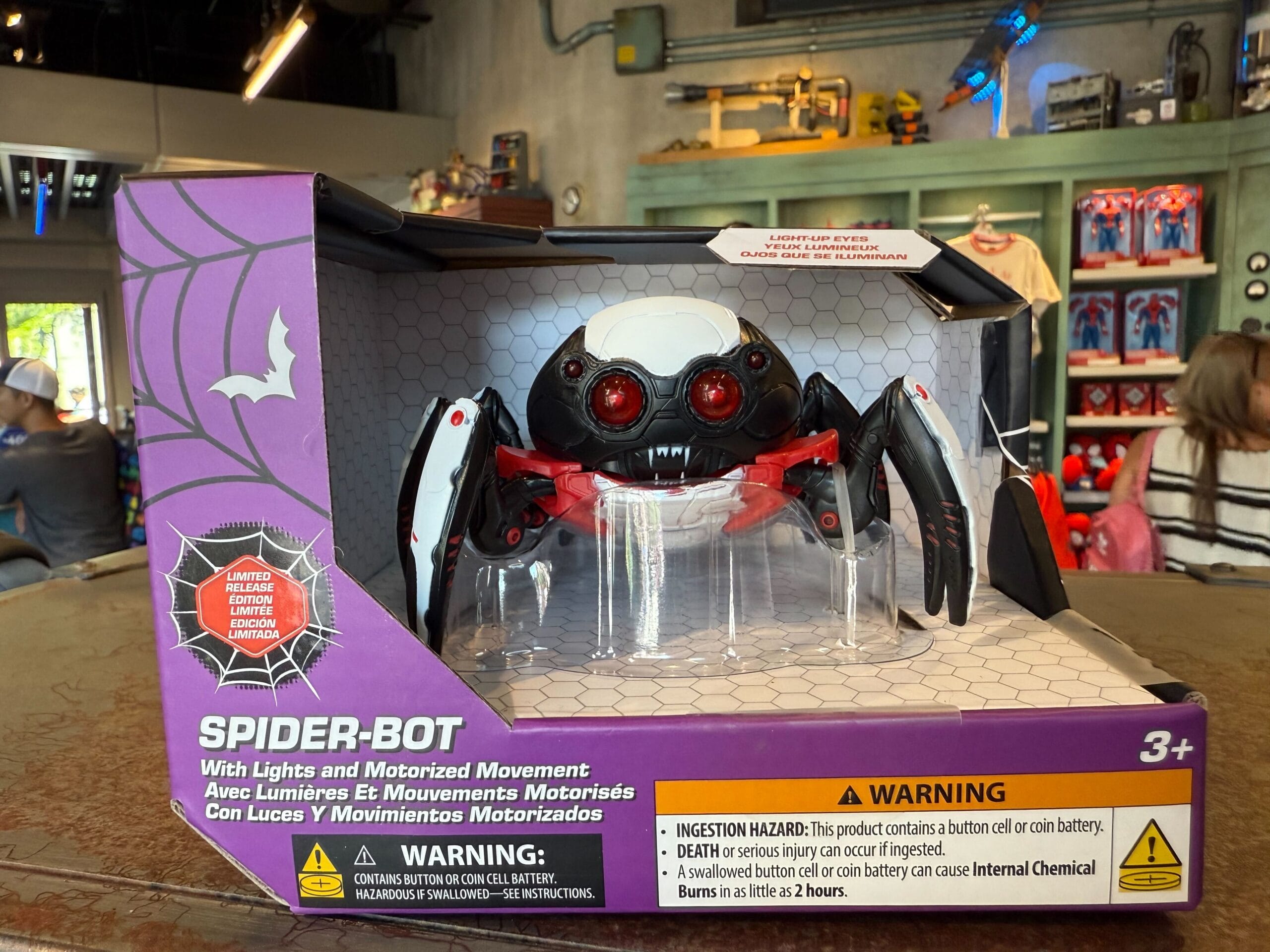 Halloween Spider-Bot toy with lights and moving parts displayed in packaging, warning labels visible.
