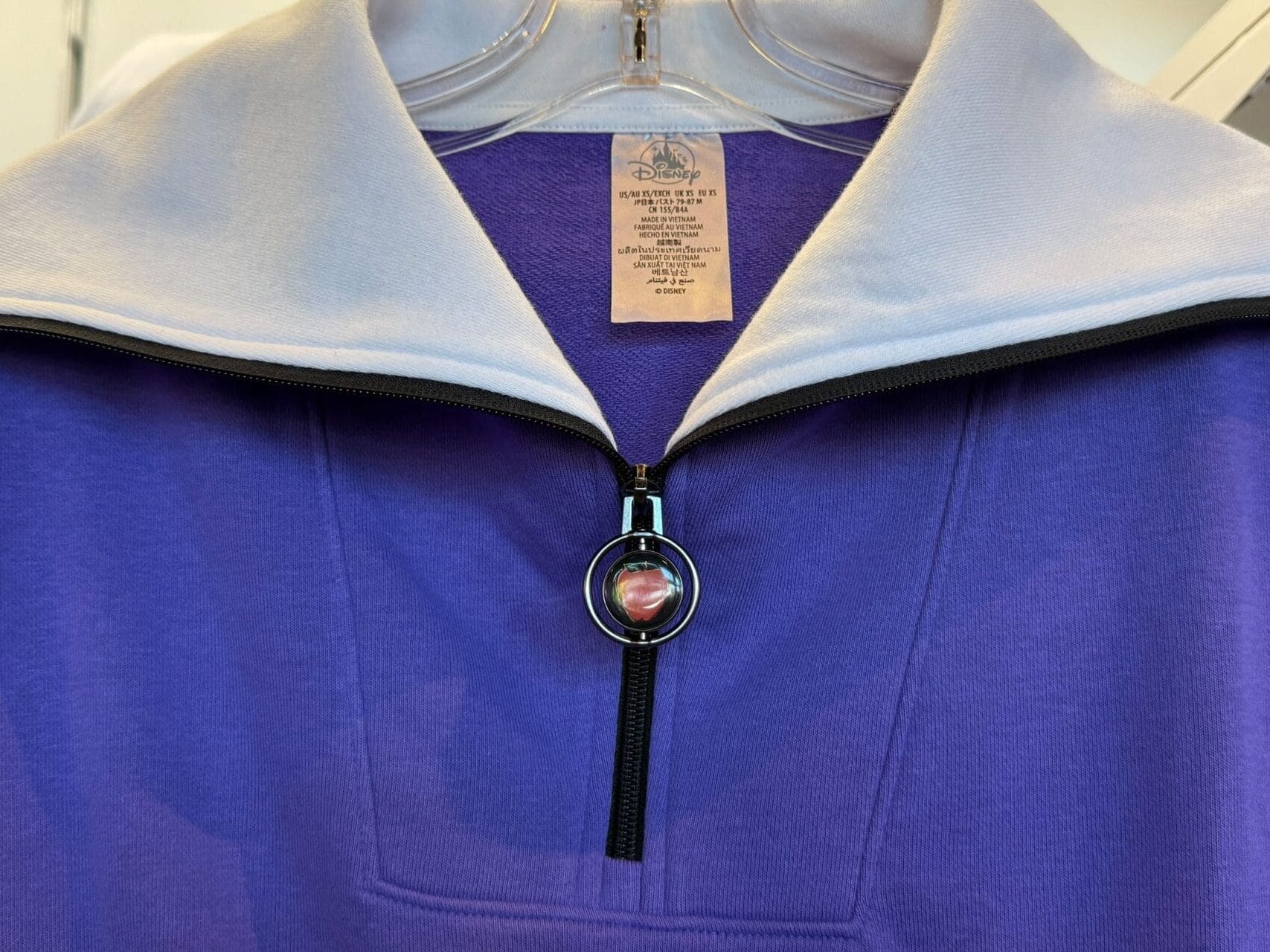 A purple pullover with a white collar and front zipper, part of the Villains Apparel merchandise at Disneyland Resort.