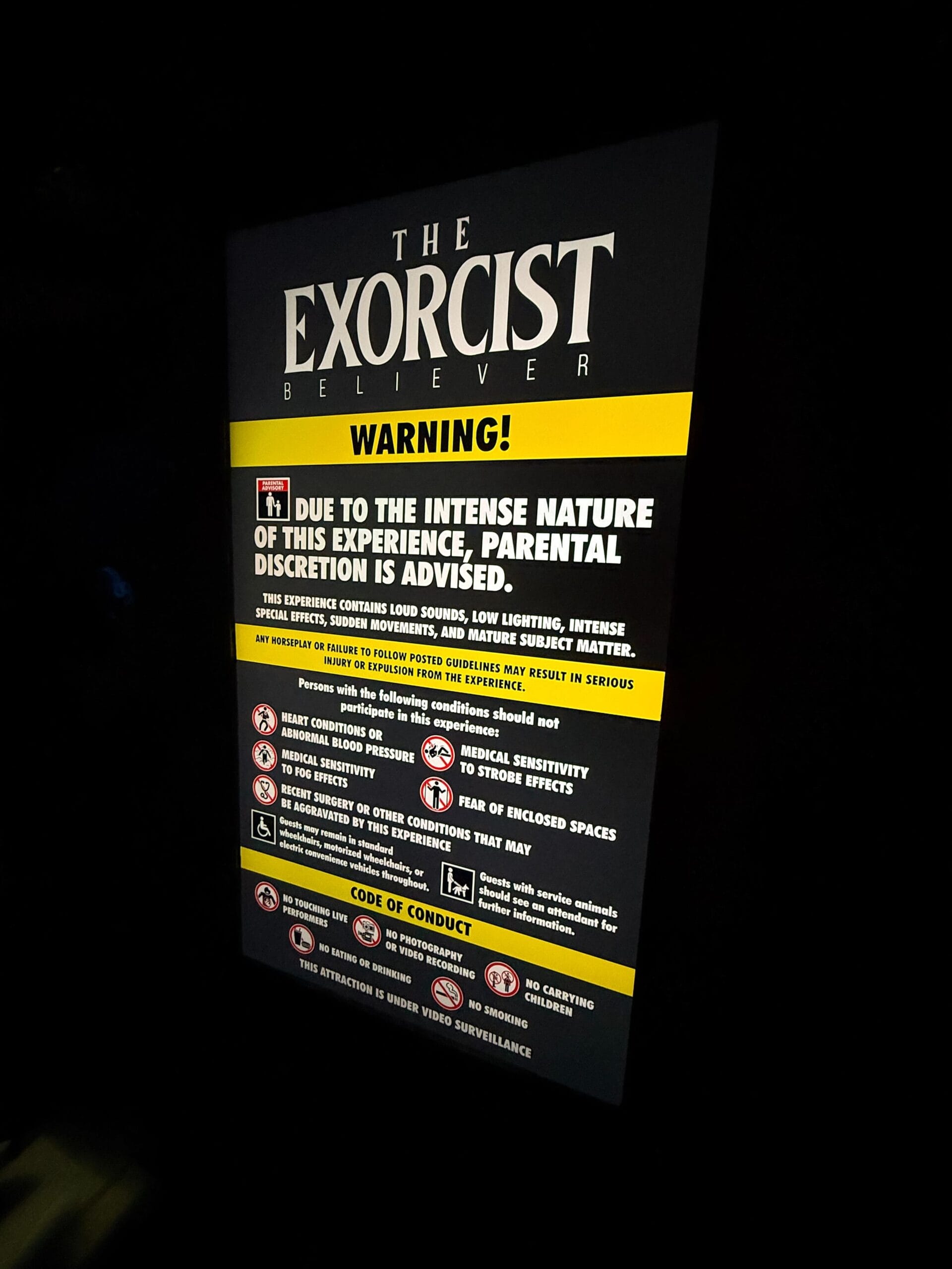A warning sign for Universal Horror Unleashed: The Exorcist: Believer House, advising parental discretion for intense content.