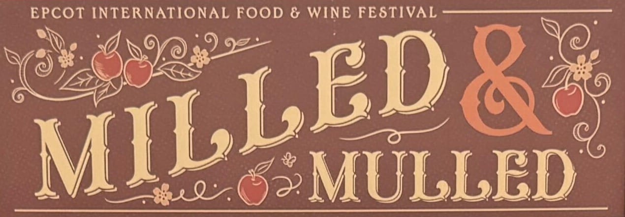 Sign reading "Epcot International Food & Wine Festival: Milled & Mulled" adorned with apples and floral designs.