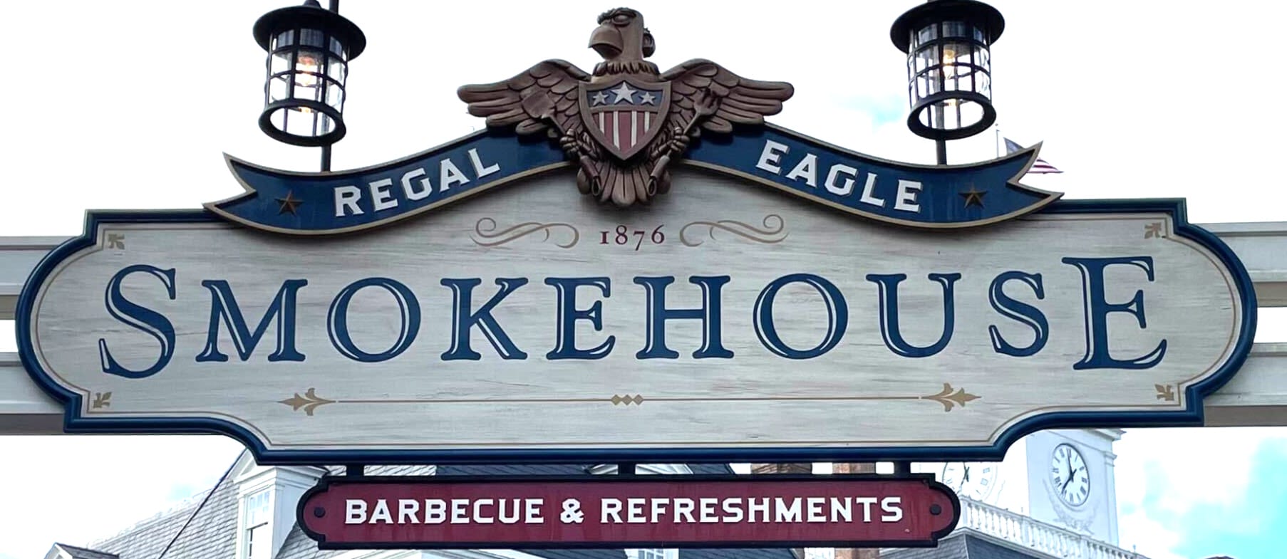 Sign reading "Regal Eagle Smokehouse 1876 Barbecue & Refreshments" with an eagle emblem, decorative lights, and Sommerfest vibe.