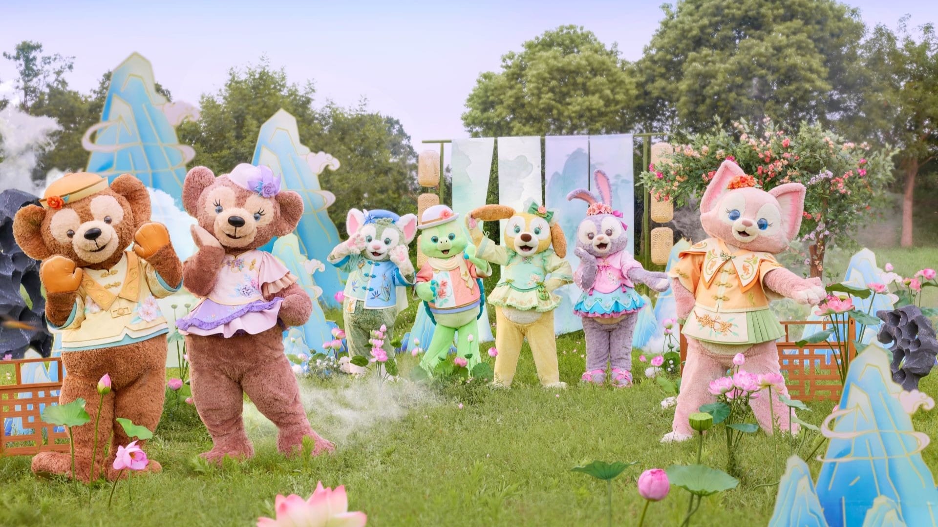 Six colorful, costumed animal mascots pose outdoors at Shanghai Disney Resort with flowers, trees, and painted mountains behind.
