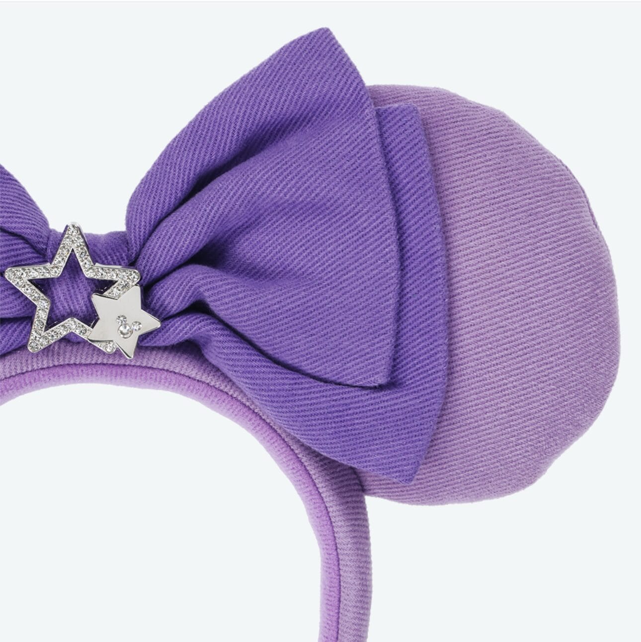 Purple headband from Tokyo Disney Resort with round padded ear, large bow, and two silver star charms on the bow.